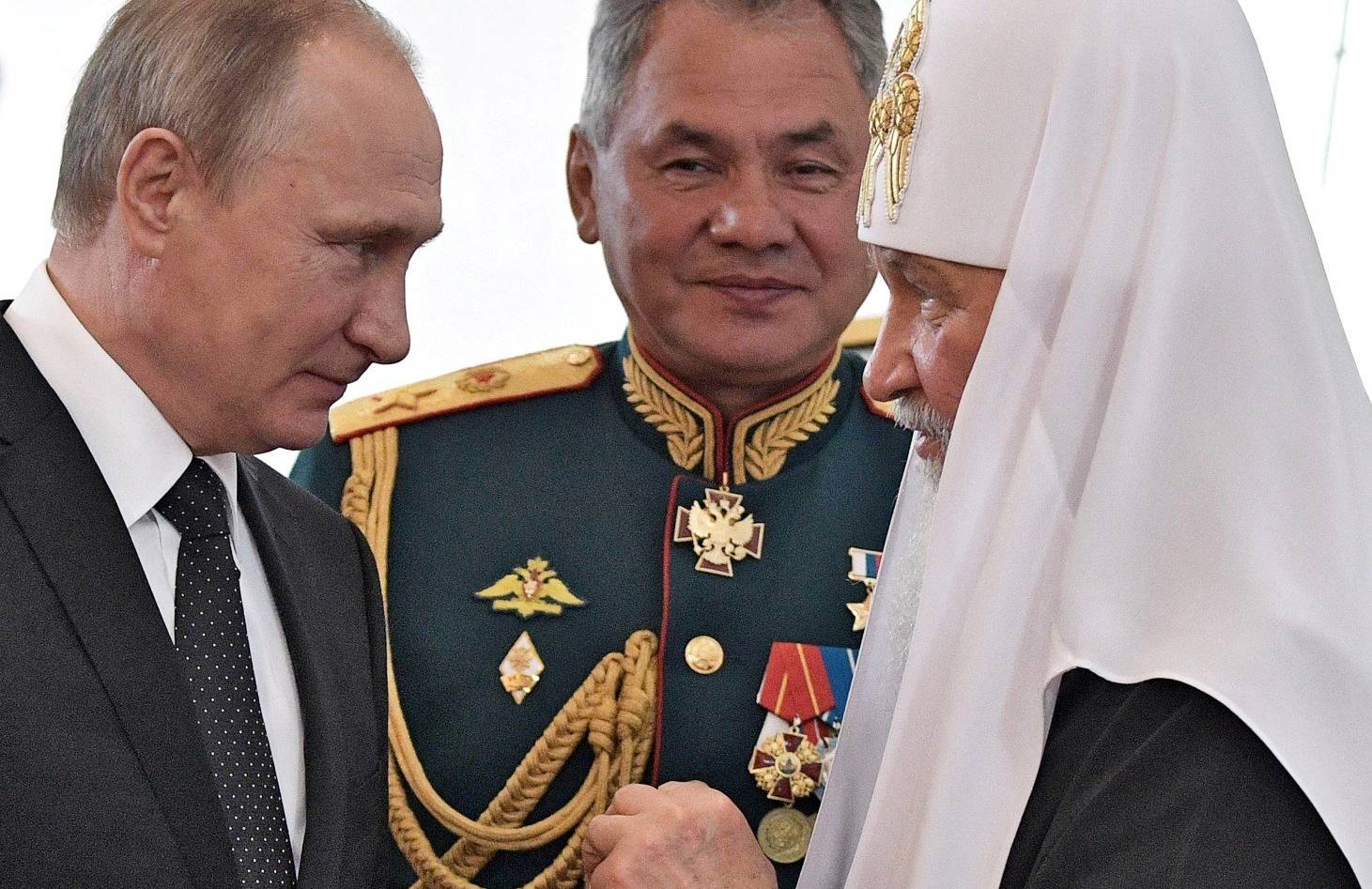 Putin z lewej, patriarcha Cyryl z prawej, w tle Szojgu w mundurze generalskim
