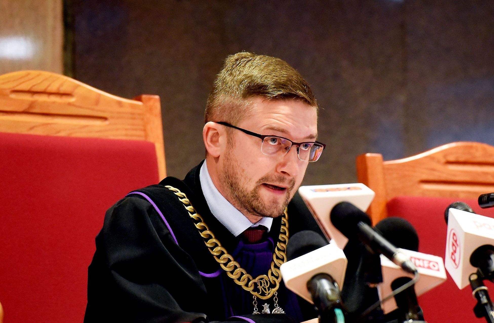 Mężczyzna w todze za stołem sędziowskim
