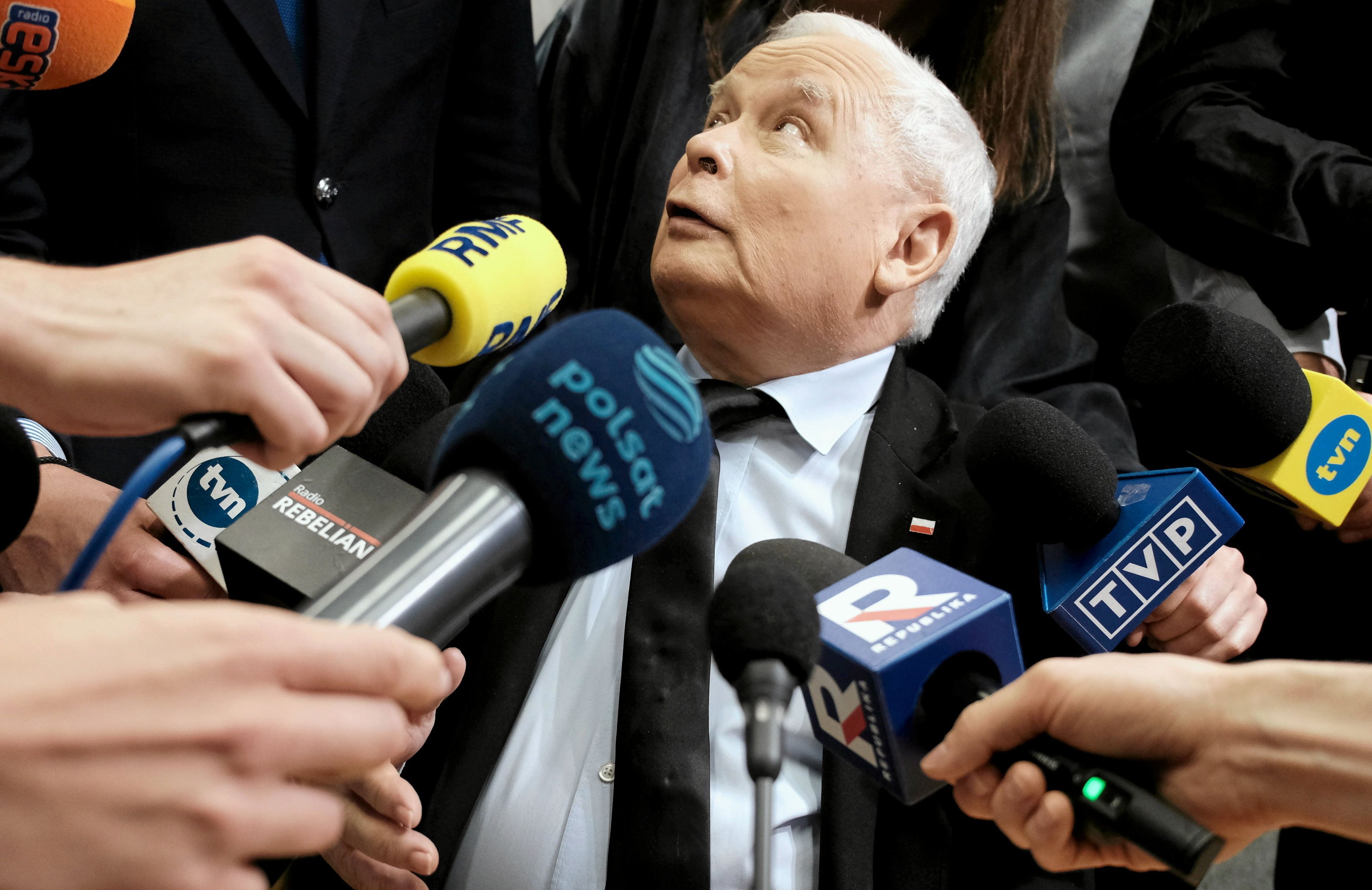 Jarosław Kaczyński w otoczeniu dziennikarzy, częściowo zasłonięty mikrofonami zerka do góry, na posiedzeniu sejmowej komisji śledczej ds. afery wizowej, 7 czerwca 2024. PKW sprawdza sprawozdanie PiS