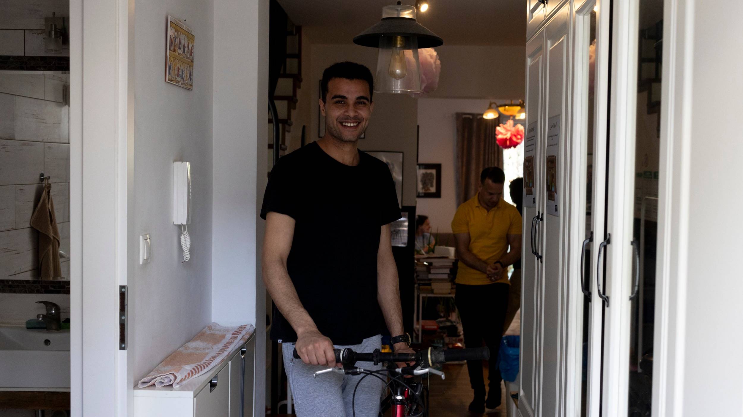 Młody mężczyzna wychodzi z rowerem z mieszkania