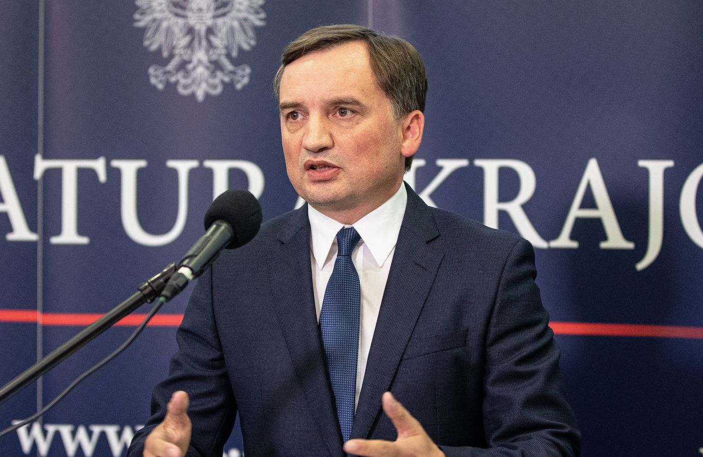 Zbigniew Ziobro przemawia z logo Prokuratury w tle