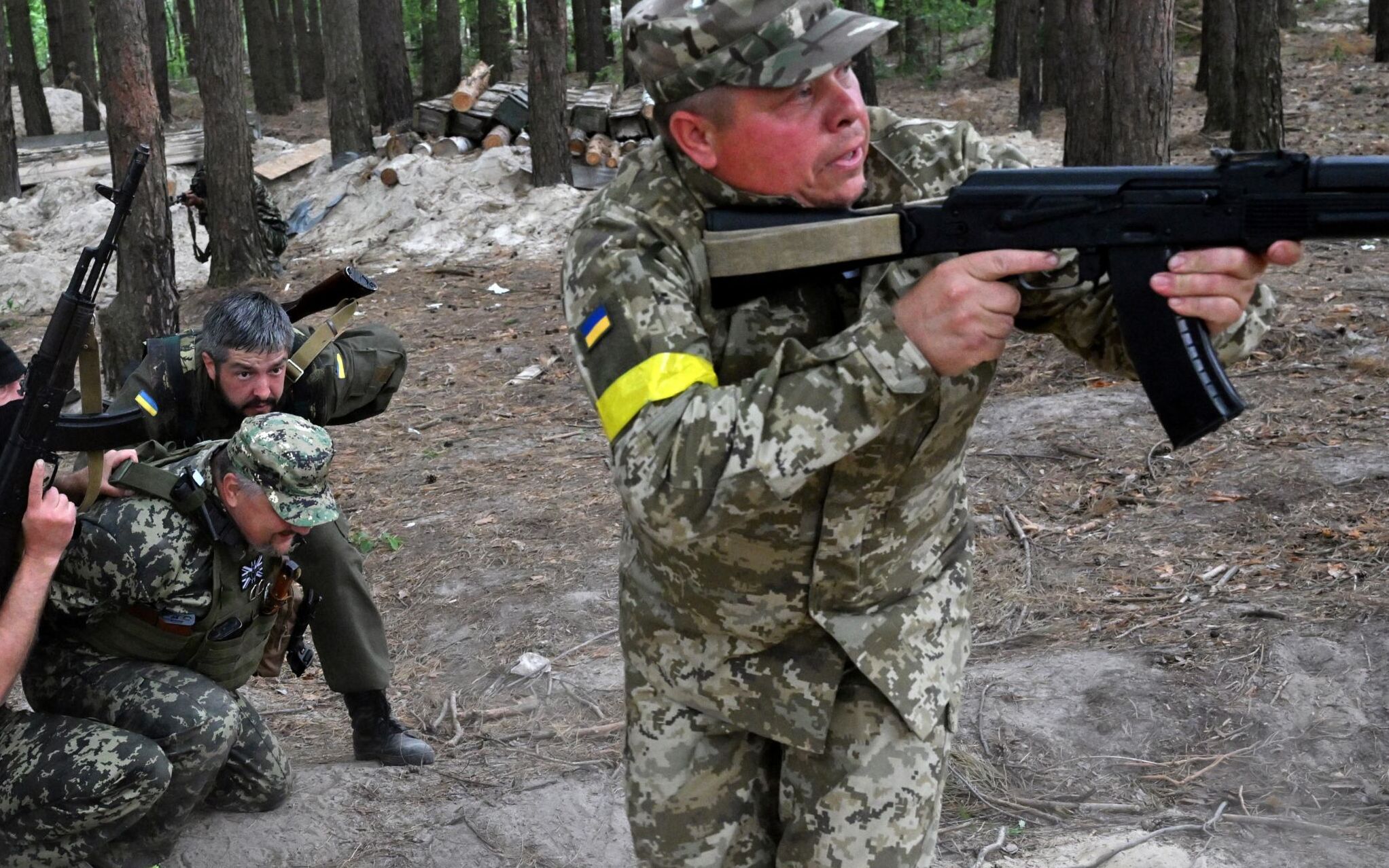 Fighters of the territorial defence unit, a support force to the regular Ukrainian army, take part in an exercise for the regular combat tactics classes, not far from the Ukrainian town of Bucha, Kyiv region on June 17, 2022. (Photo by Sergei SUPINSKY / AFP)