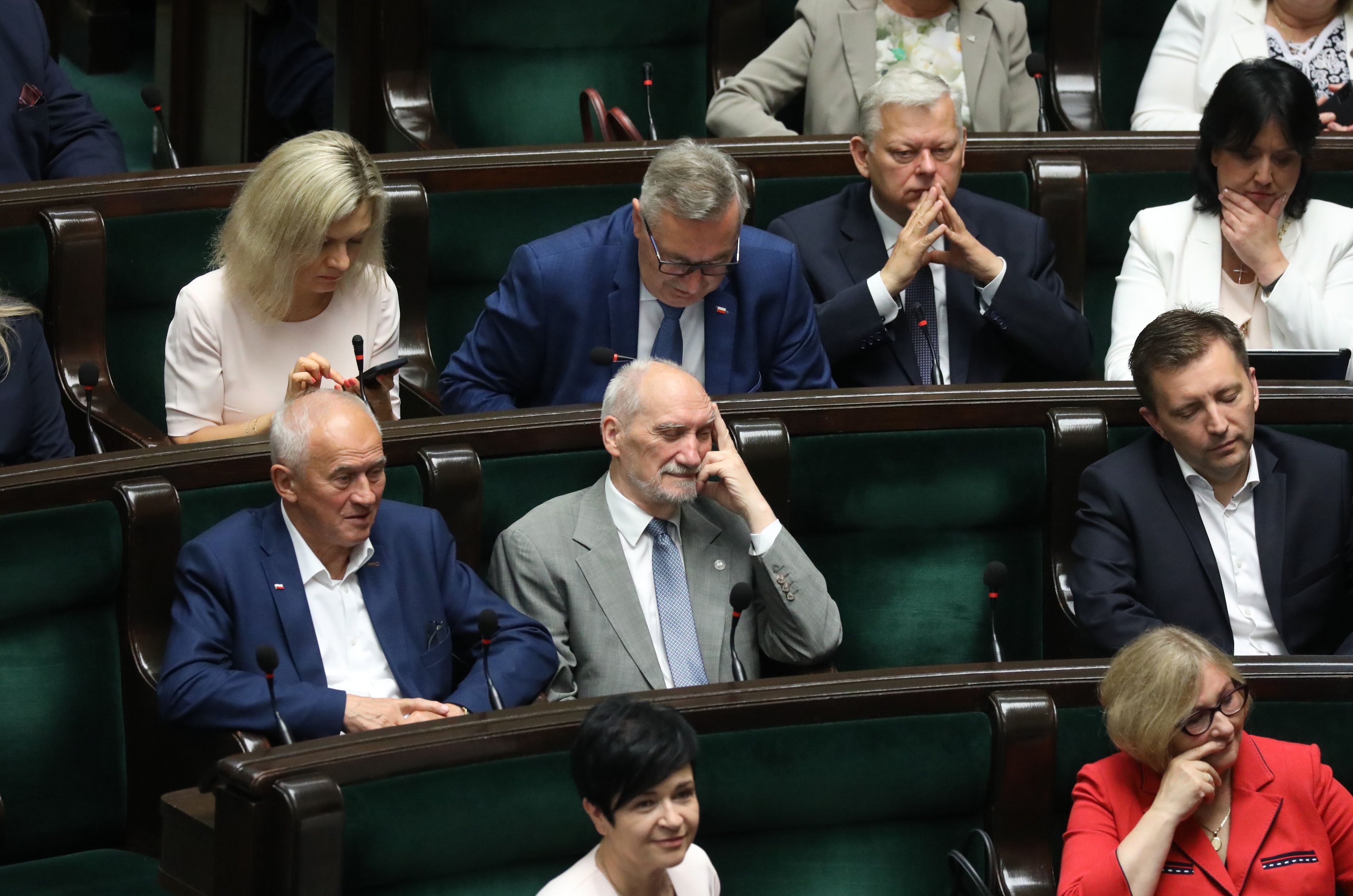 Posłowie PiS w ławach sejmowych w dyskusji o referendum i 800 Plus robią rękami różne nieskładne gesty