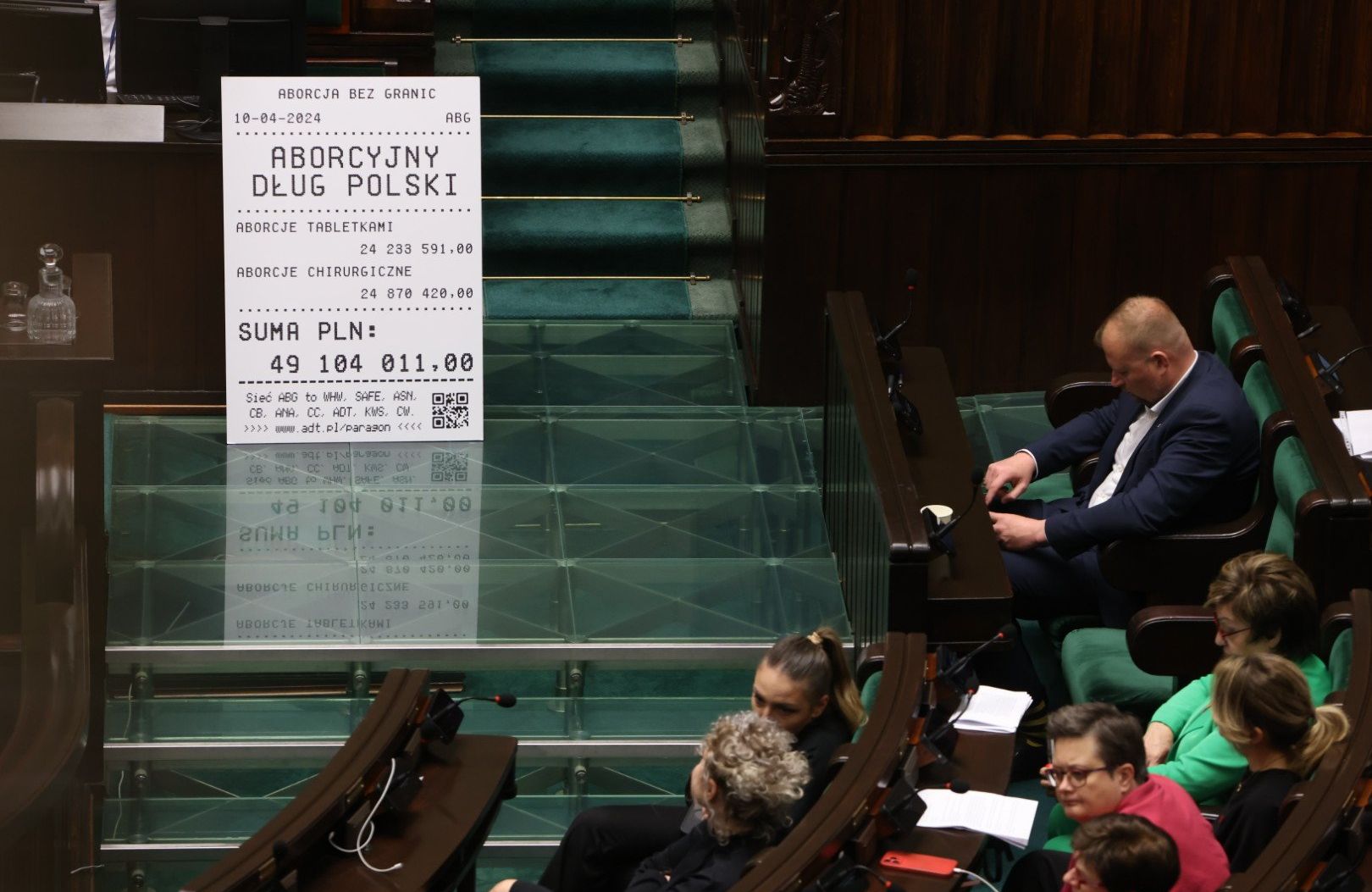 baner z długiem aborcyjnym przy mównicy sejmowej