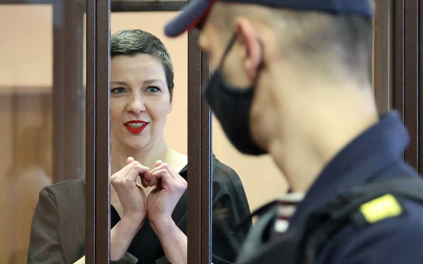 Maria Kolesnikova, the last remaining protest leader still in Belarus, gestures making a heart shape inside the defendants' cage during her verdict hearing on charges of undermining national security, conspiring to seize power and creating an extremist group, on September 6, 2021 in Minsk. - A court in Belarus sentenced key opposition figure Maria Kolesnikova -- who led mass protests against President Alexander Lukashenko last year -- to 11 years in prison on national security charges. Kolesnikova, a 39-year-old former flute player in the country's philharmonic orchestra and the only protest leader still in Belarus, has become a symbol of the protest movement in Belarus where Lukashenko, in power since 1994, has been cracking down on opponents since unprecedented protests erupted after last year's elections, deemed unfair by the West. (Photo by Ramil NASIBULIN / BELTA / AFP) / Belarus OUT / BELARUS OUT