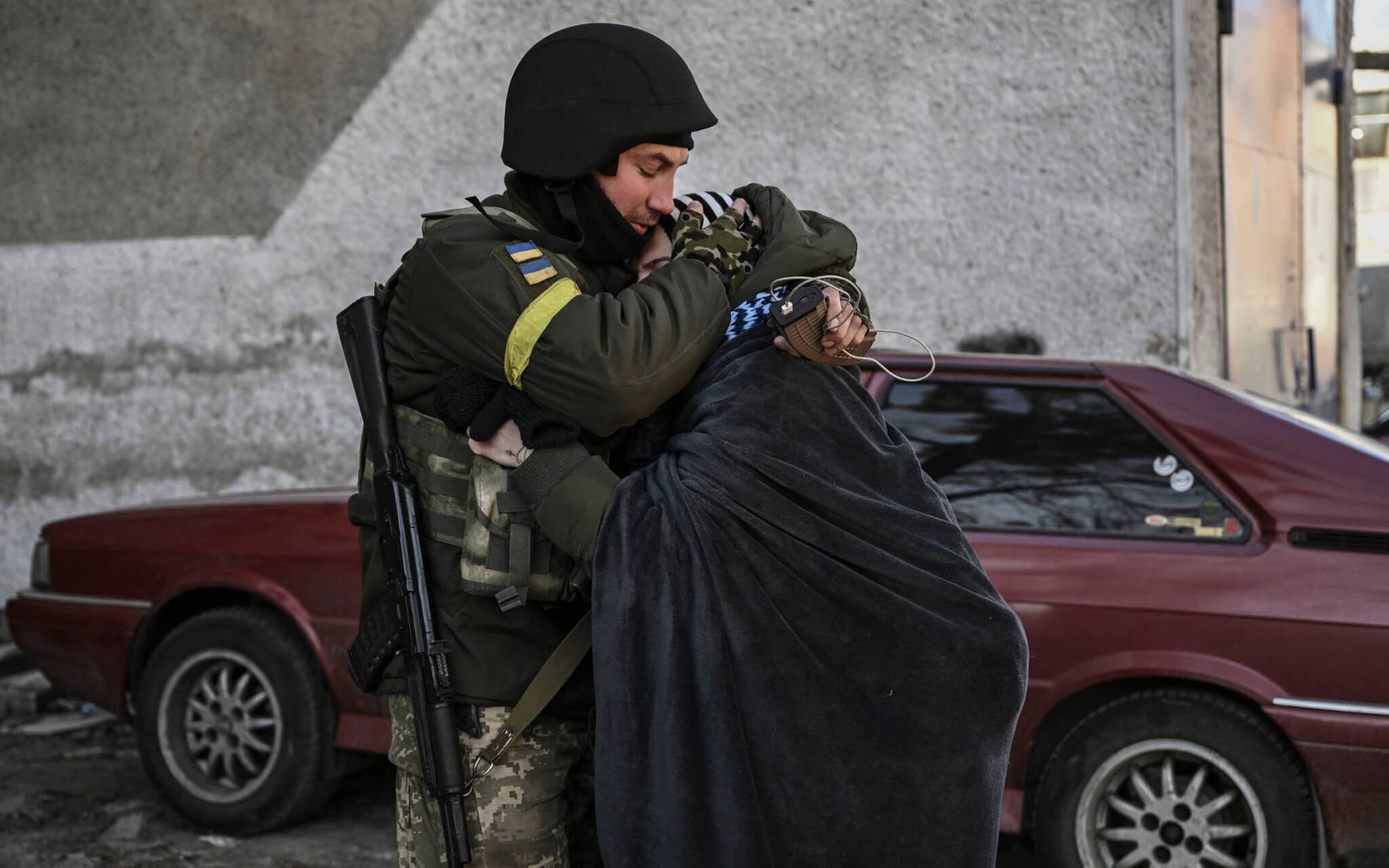 A Ukranian soldier hugs his wife in the city of Irpin, north of Kyiv, on March 10, 2022. - Russian forces on March 10, 2022 rolled their armoured vehicles up to the northeastern edge of Kyiv, edging closer in their attempts to encircle the Ukrainian capital. Kyiv's northwest suburbs such as Irpin and Bucha have been enduring shellfire and bombardments for more than a week, prompting a mass evacuation effort. (Photo by Aris Messinis / AFP)