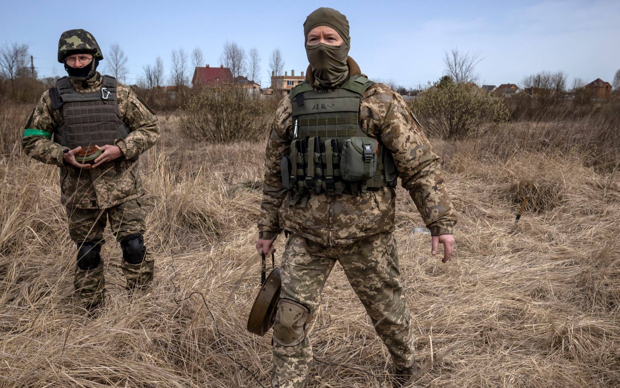 Members of a bomb disposal squad walk in a mine field near Brovary, northeast of Kyiv, on April 14, 2022, amid Russia's military invasion launched on Ukraine. - Russia called off its northern offensive to take Kyiv at the end of March, and since then Ukrainian citizens and soldiers have returned to the land they occupied. In recent weeks AFP has seen countless unexploded munitions lying in the streets of towns and villages north-east and north-west of the capital, abandoned or mislaid in the hasty withdrawal. (Photo by FADEL SENNA / AFP)