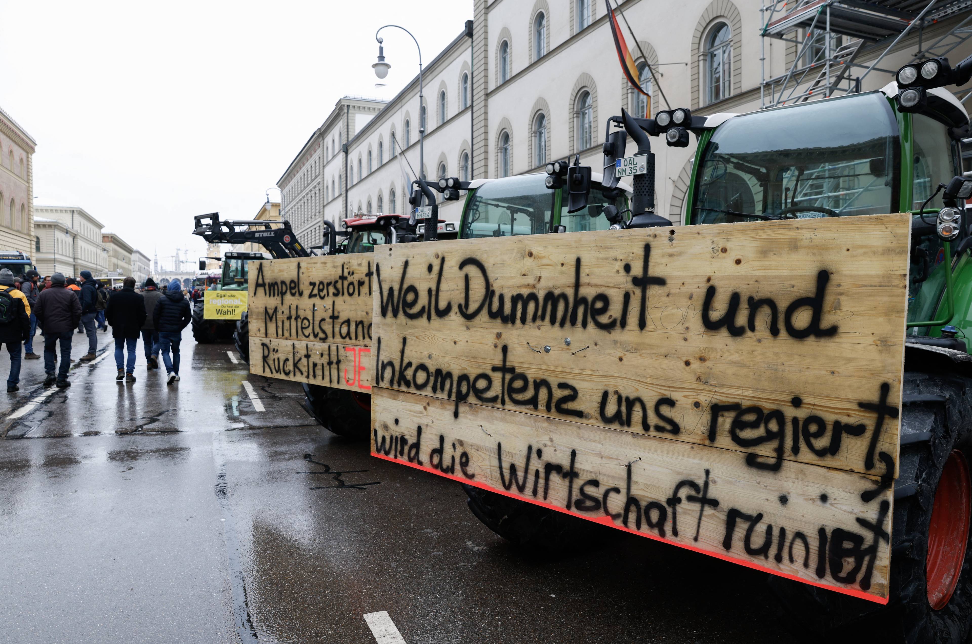 Kolumna traktorów w mieście, na nich hasło: Kiedy rządzą głupota i niekompetencja, gospodarka jest w ruinie. Niemiecka gospodarka
