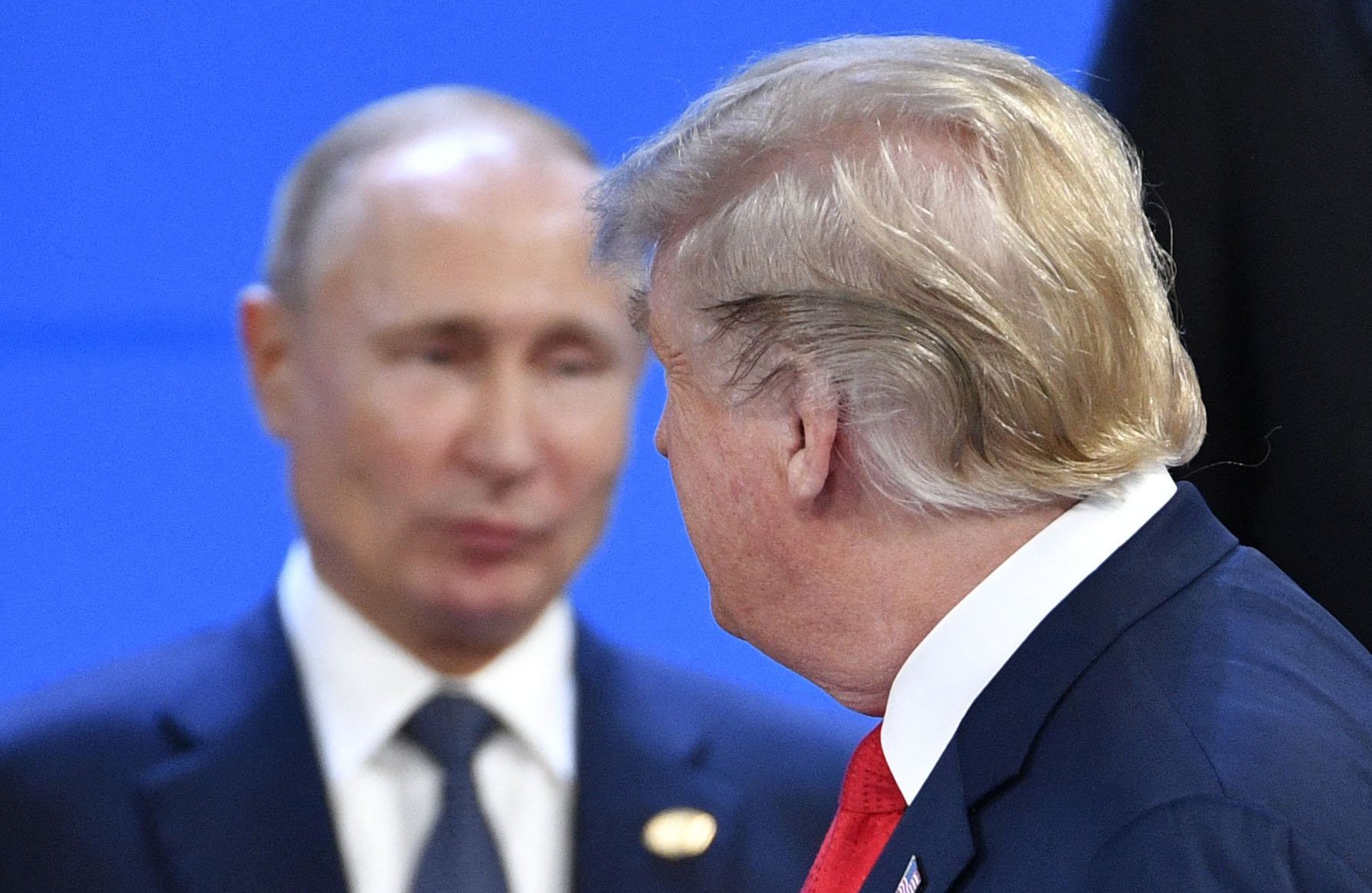 tył głowy trumpa, w tle putin