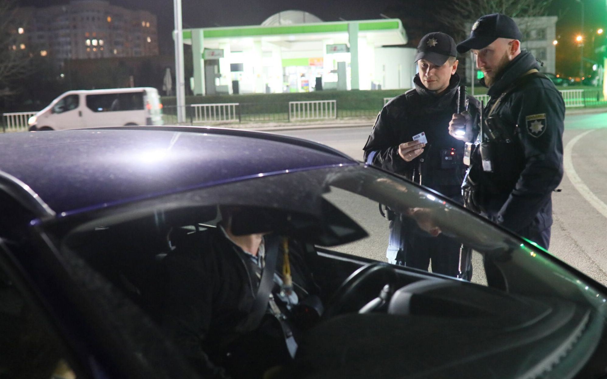Ukrainian policemen check driver's documents as they patrol in western Ukrainian city of Lviv on March 28, 2022, on the 34th day of the Russian invasion of Ukraine. - Ukraine is calling for an "international agreement" to guarantee its security, which would be signed by several guarantor countries, said on March 29, 2022 the Ukrainian chief negotiator after several hours of Russian-Ukrainian talks in Istanbul. (Photo by Aleksey Filippov / AFP)