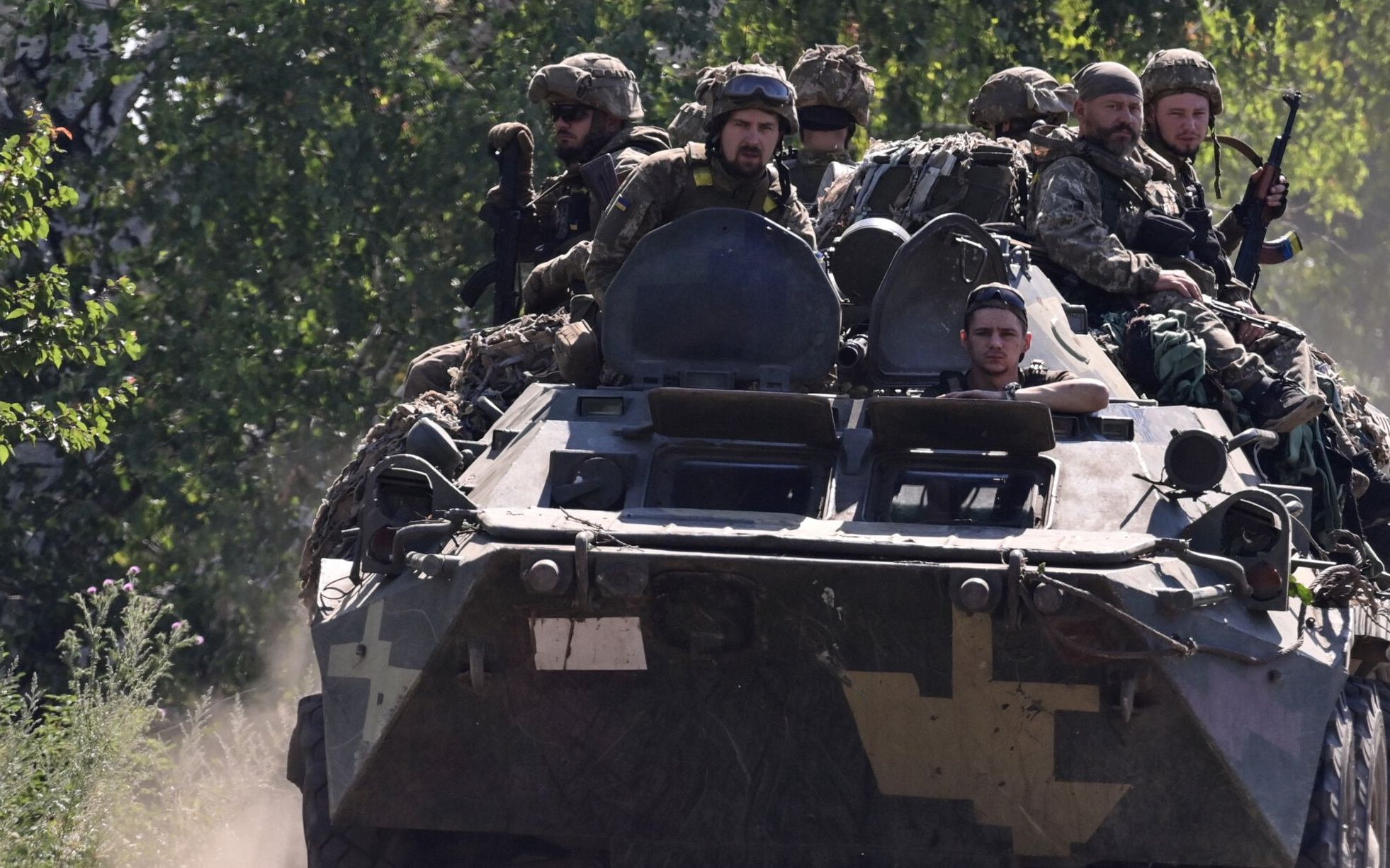 Ukrainian soldiers on top of an Ukrainian armoured fighting vehicle are pictured on a road in the countryside of Siversk, in Donetsk Oblast, eastern Ukraine, on July 8, 2022, amid the Russian invasion of Ukraine. (Photo by MIGUEL MEDINA / AFP)