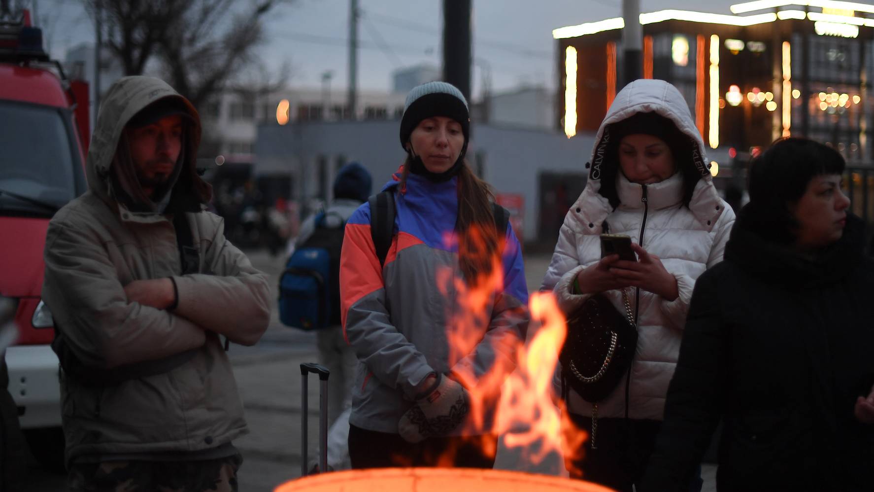 Refugees warm up around a bonfire outside the Lviv train station, western Ukraine, on March 03, 2022. - Ukraine and Russia agreed to create humanitarian corridors to evacuate civilians on March 03 in a second round of talks since Moscow invaded last week, a top Ukrainian official said. (Photo by