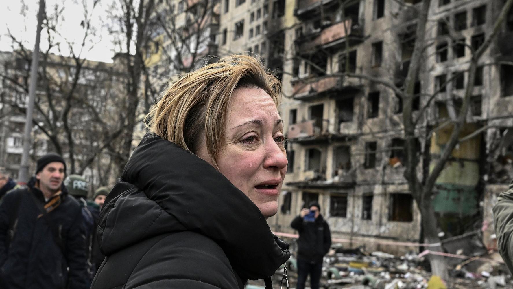 Ukrainka na tle zniszczonego budynku w Kijowie