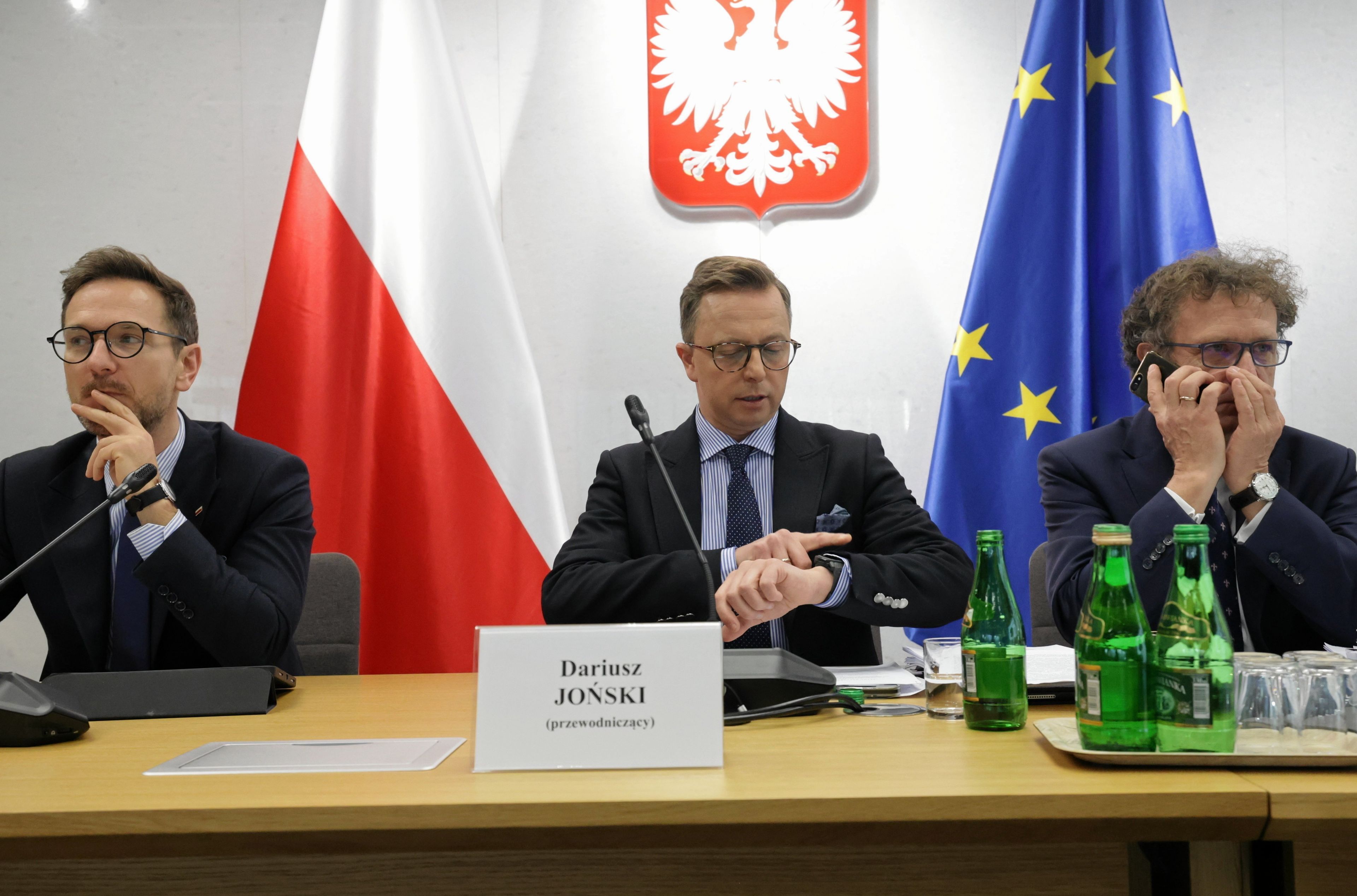 trzech posłów siedzi przy stole