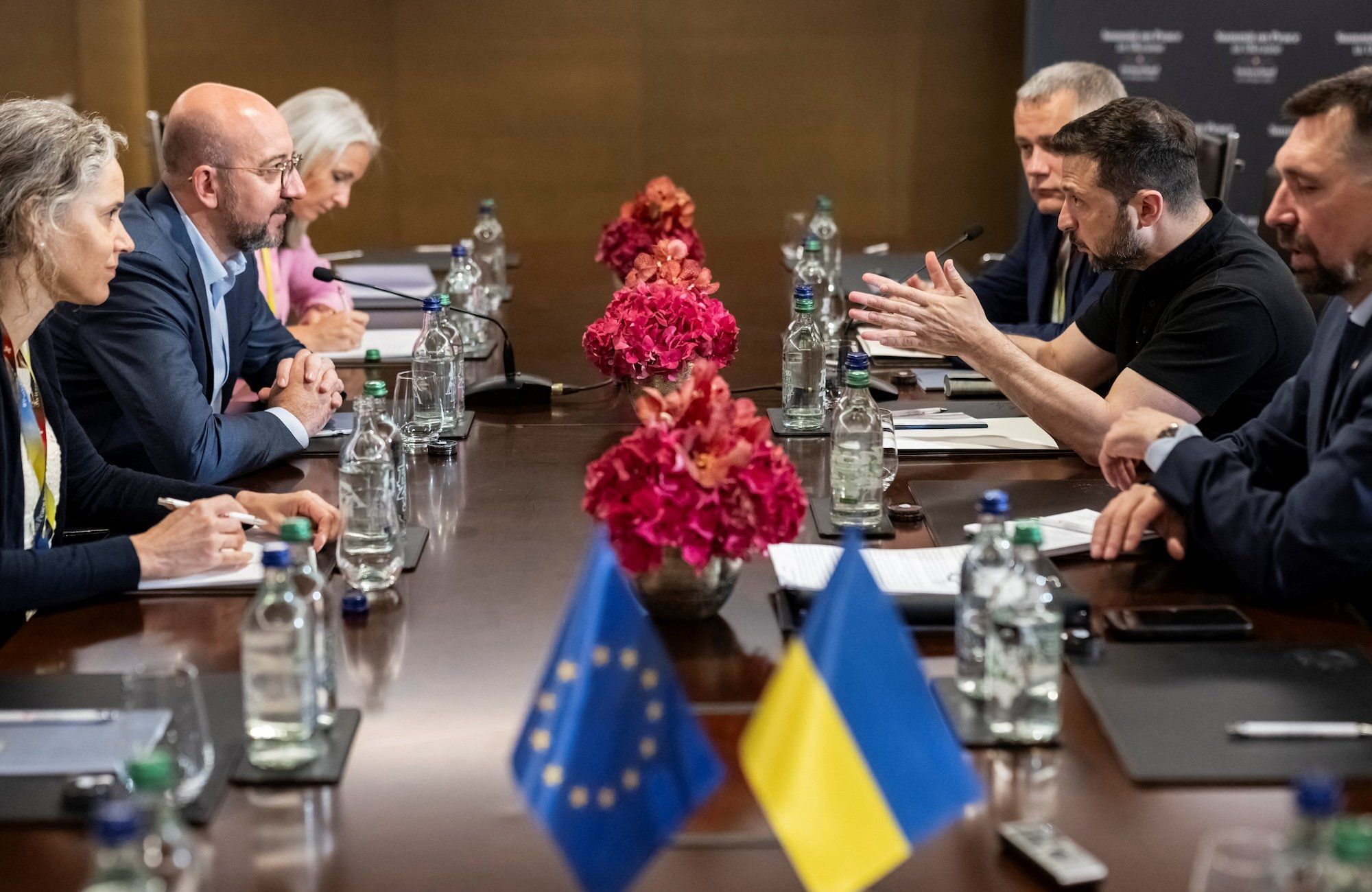Negocjacje podczas szczytu nt. Ukrainy w Szwajcarii. Za stołem na przeciwko siebie szef Rady Europejskiej Charles Michel i prezydent Ukrainy Wołodymyr Zełenski