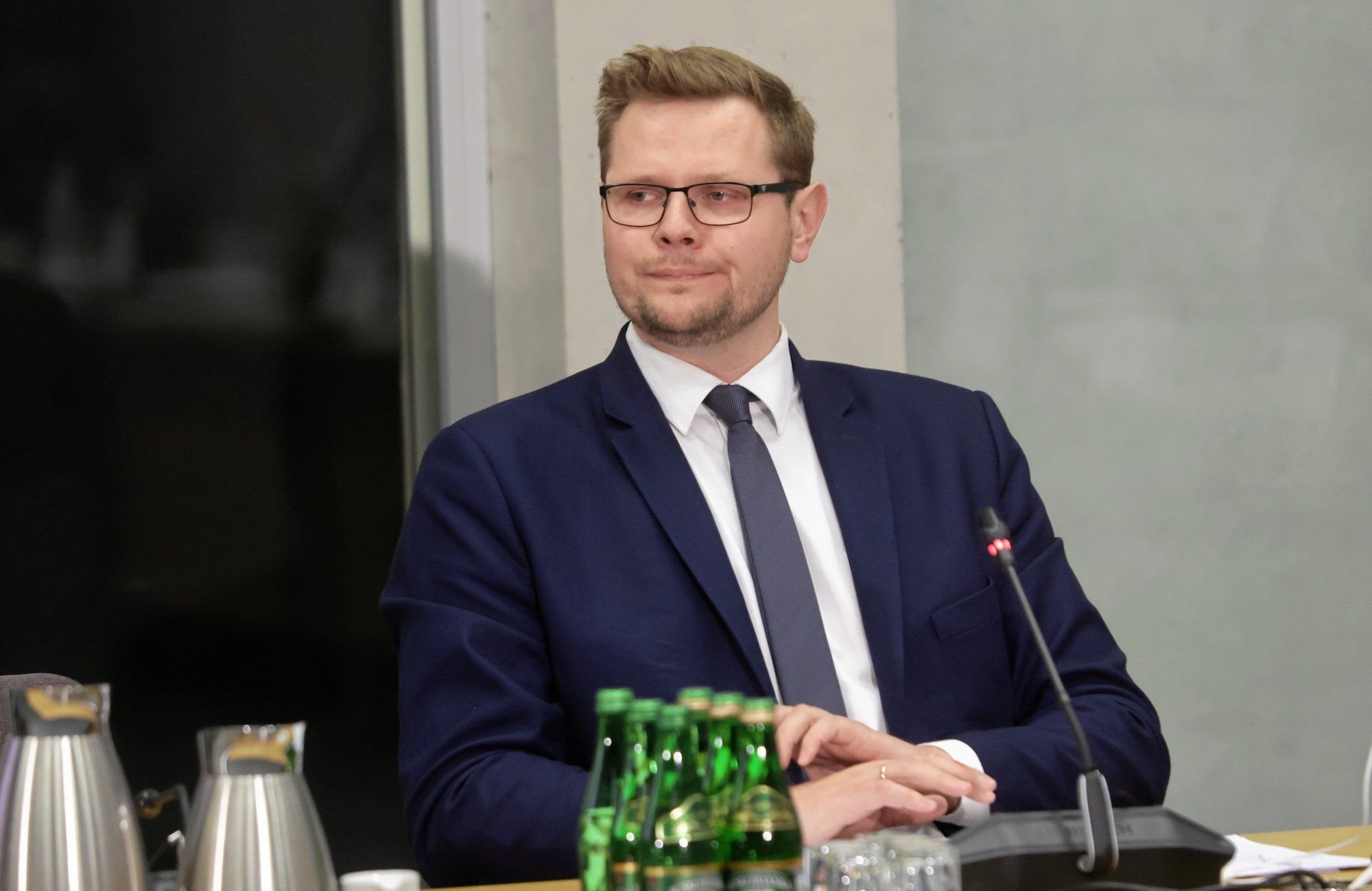 Michał Woś w granatowym garniturze podczas przesłuchania przed sejmową komisją śledczą