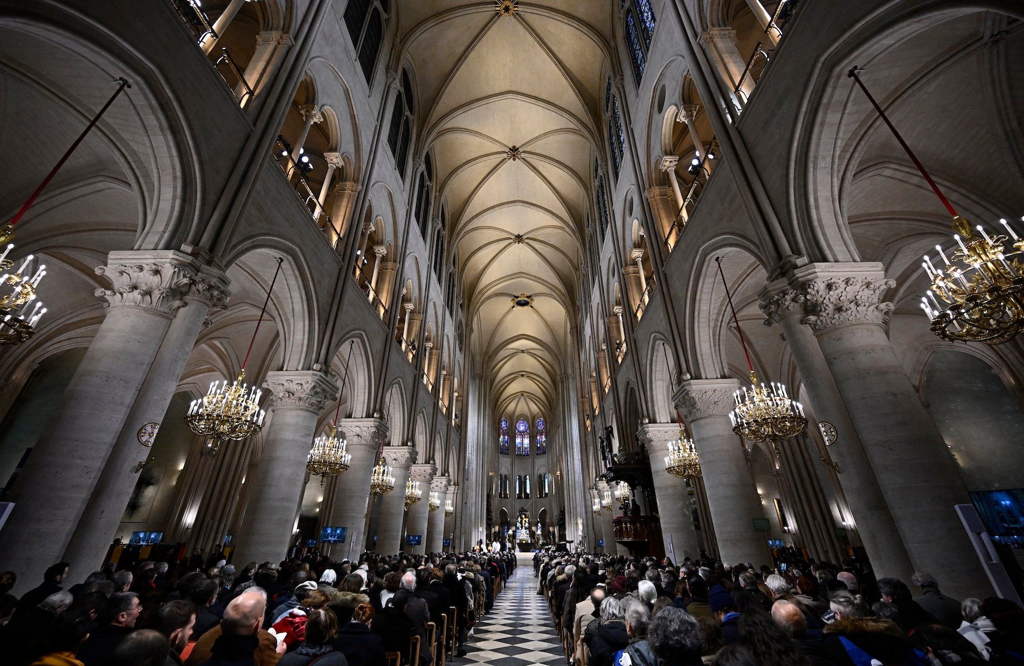 Wnętrze odbudowanej po pożarze katedry Notre-Dame w Paryżu. Nawa główna z jasnego kamienia.
