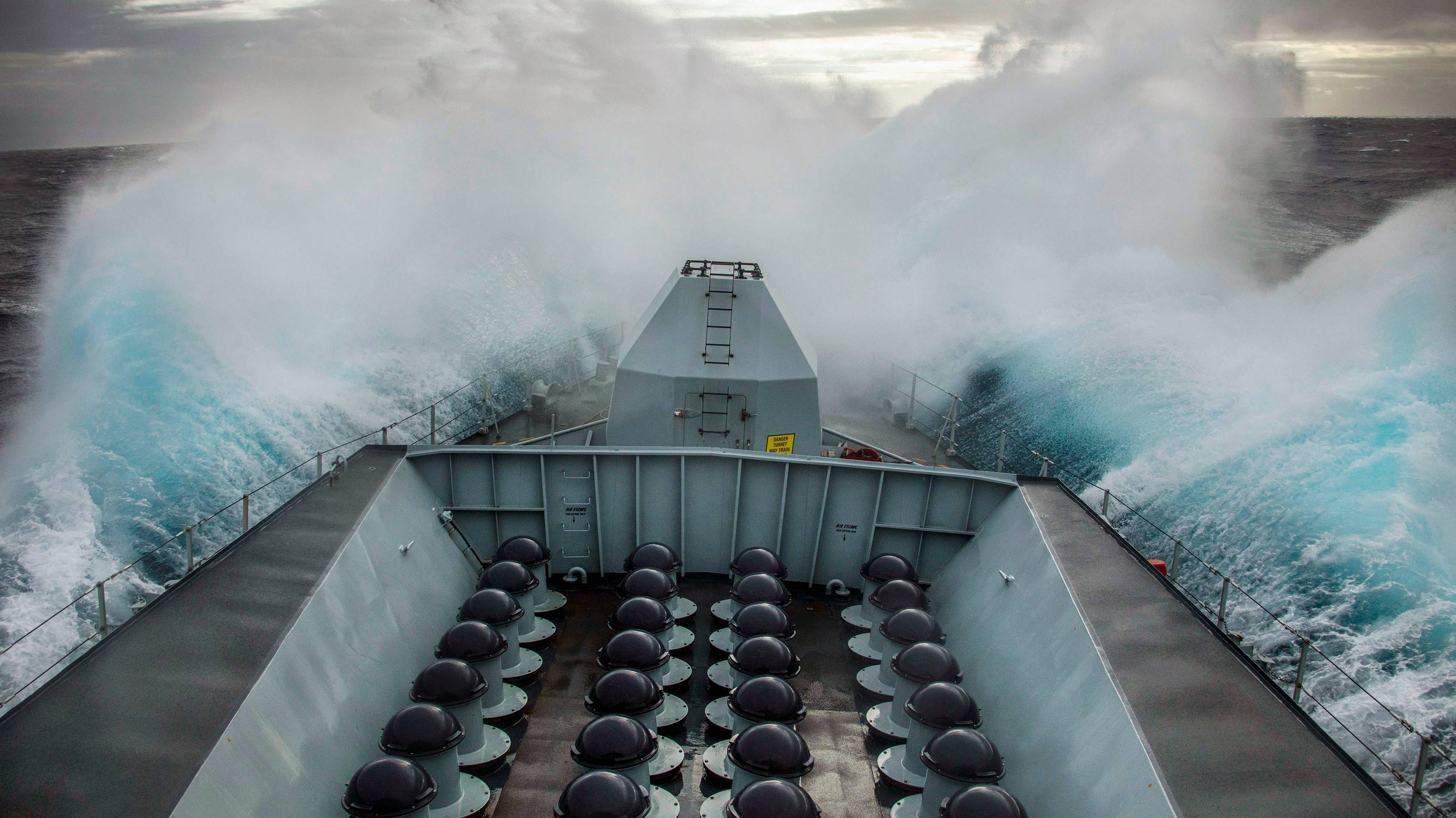 Pictured, Waves crash over HMS Lancaster's bow as she transits along Norway's coastline.

On 26th March 2021, HMS Lancaster started her transit south from Norway having been exercising with the Norwegian Frigate  THNoMS Thor Heyerdahl.

During the transit south down the the Norwegian coastline she encountered high seas which made for some impressive wave formations crashing over her bow.

The Type 23 Frigate from HMNB Portsmouth will conduct a short stint of maritime security patrols around the UK coastline before taking over duties as the Fleet Ready Escort Ship.

All the ships in the Type 23 class are named after Dukes, in this case, the Duke of Lancaster.

HMS Lancaster recently had a major refit and some of her new equipment includes a new Artisan 3D radar and vastly-improved air-defence capabilities provided by Sea Ceptor, replacing Sea Wolf missiles which only possess about half the Sea Ceptors range.

The hull was cleaned and coated with anti-fouling paint to prevent marine life attaching itself, the main 4.5in gun serviced, engines and machinery overhauled, new systems installed, and the bridge, messes and other communal areas revamped.