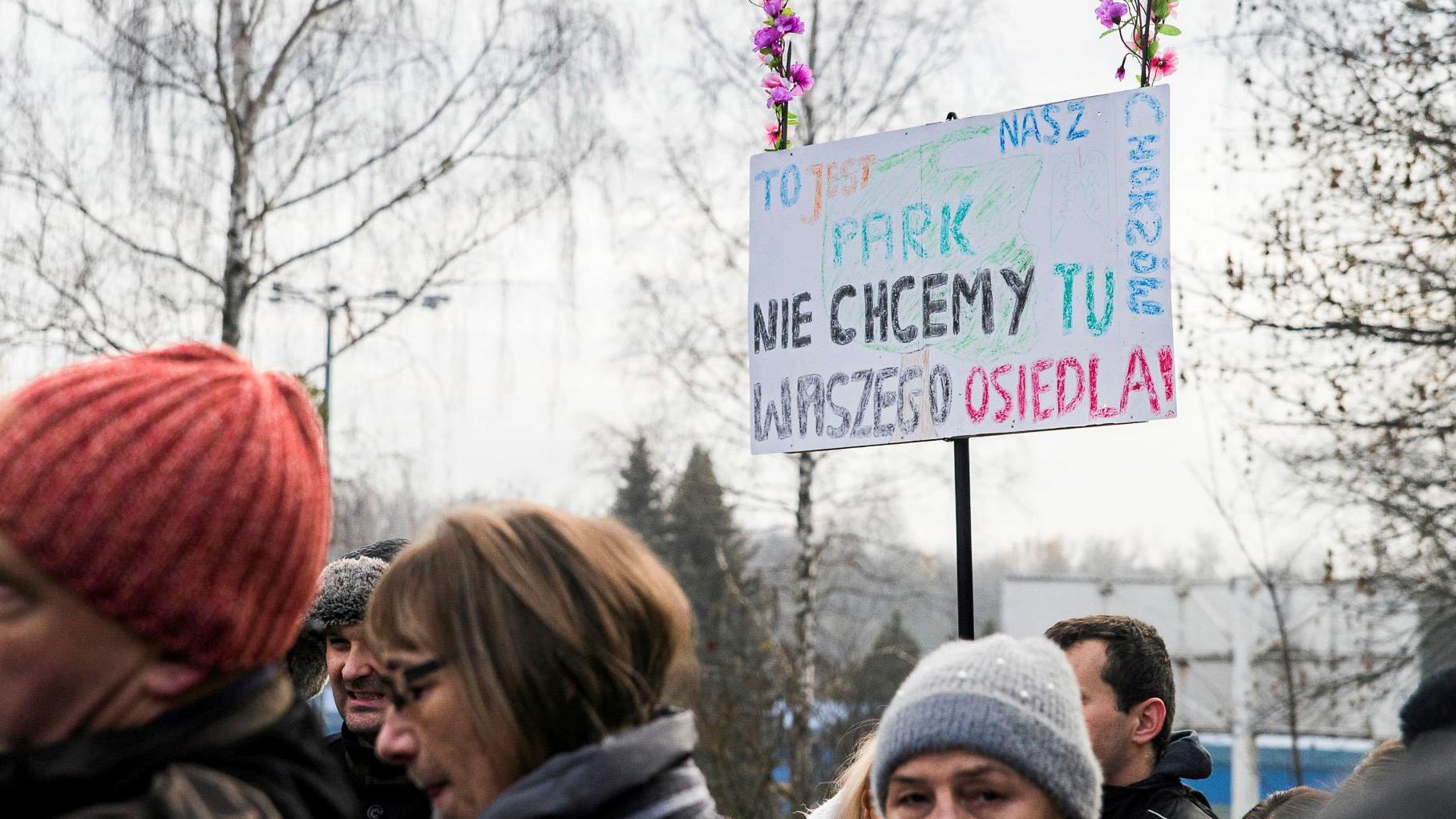 Protest w Parku Śląśkim. Widoczny jest transparent z napisem: "To jest nasz park. Nie chcemy tu Waszego osiedla"