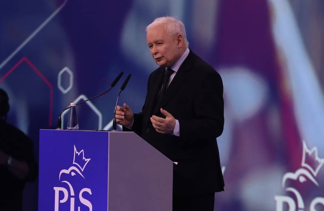 Jarosław Kaczyński podczas konwencji PiS w Warszawie. Stoi przy podium z logo PiS i przemawia do publiczności na tle dużego ledowego ekranu.