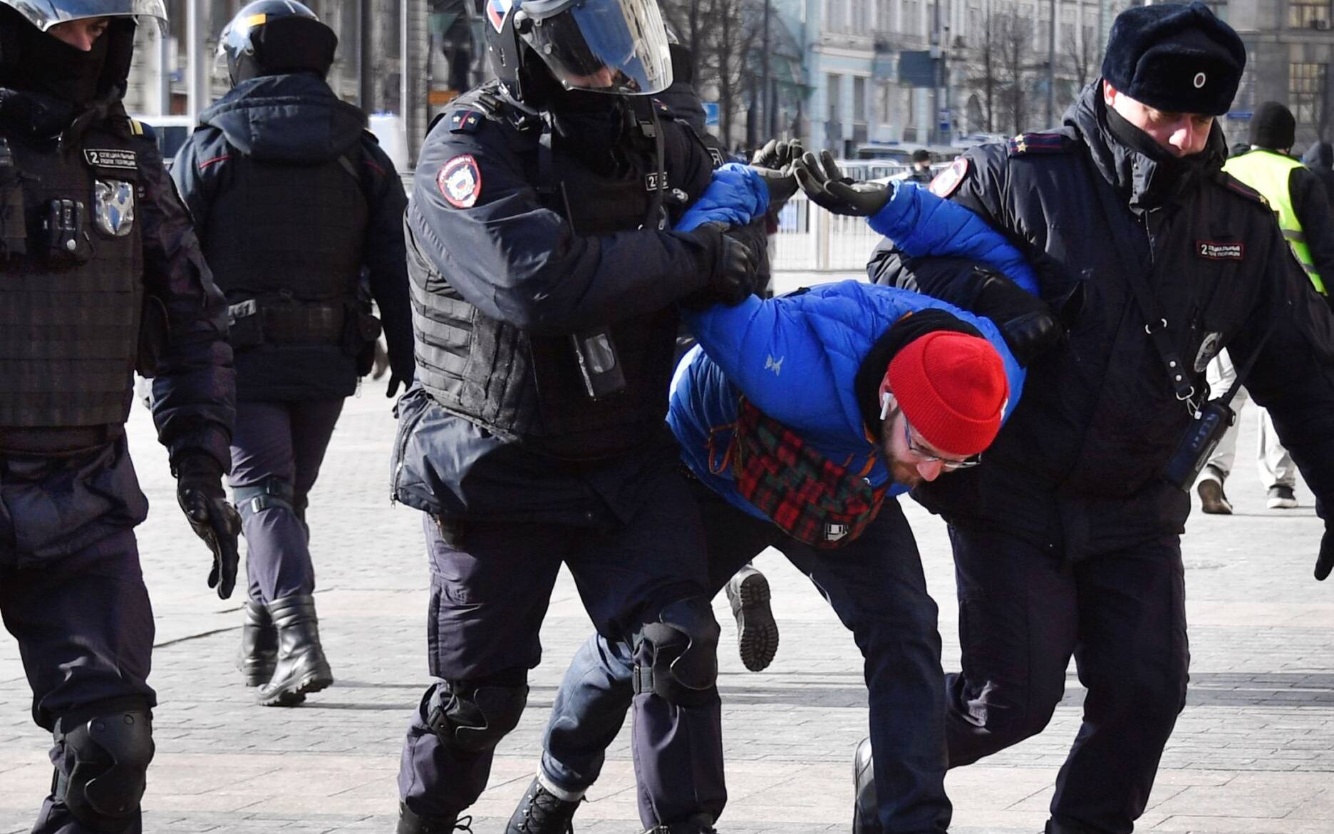 Police officers detain a man during a protest against Russia's invasion of Ukraine, in Manezhnaya square in central Moscow on March 13, 2022. (Photo by - / AFP)