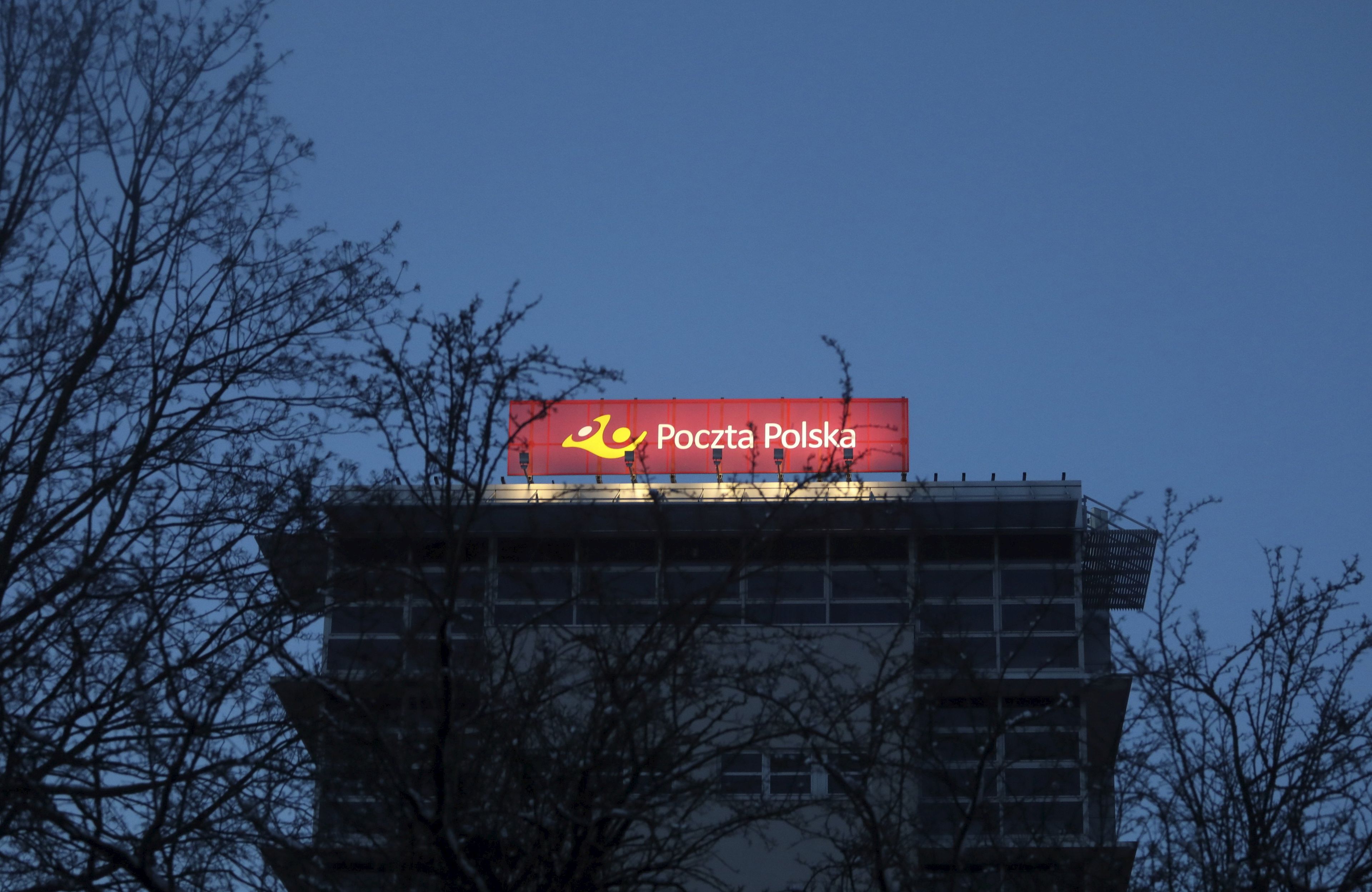 zaciemniomy budynek z podświetlonym szyldem "poczta polska" na szczycie