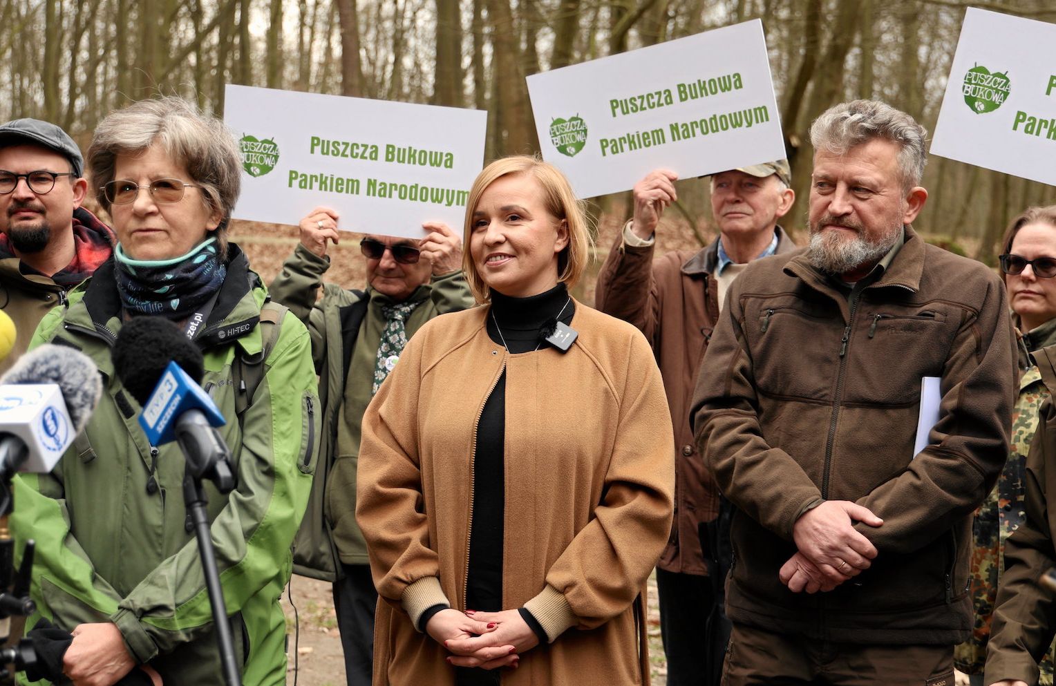 Konferencja prasowa w Puszczy Bukowej w Szczecinie. Na zdjęciu pośrodku posłanka KO Magdalena Filiks w jasnobrązowym płaszczu.