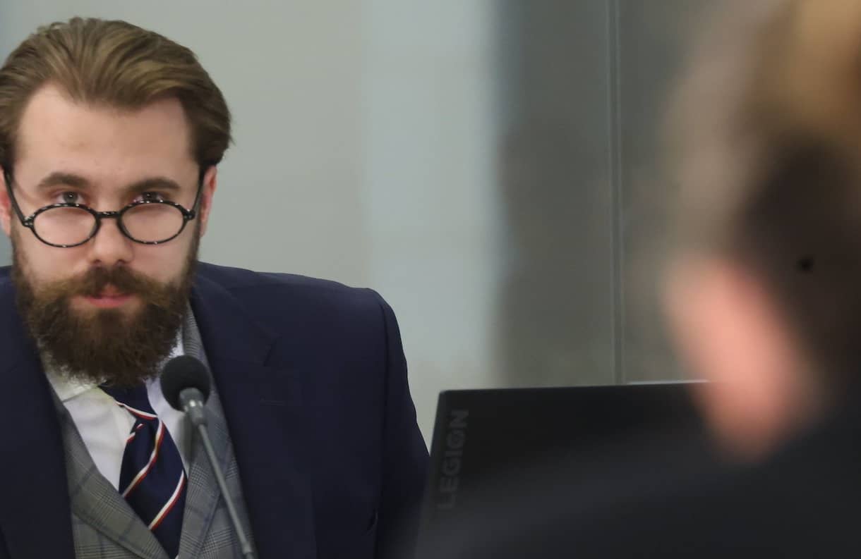 Jakub Osajda zeznaje przed komisją ds. afery wizowej. Na pierwszym planie tył głowy posłanki, która zadaje mu pytania