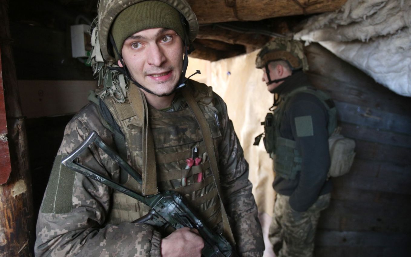 Ukrainian servicemen wait till mortar attack is over at their position on the front line with Russia-backed separatists near the town of Schastia, near the eastern Ukraine city of Lugansk, on February 23, 2022. (Photo by Anatolii Stepanov / AFP)