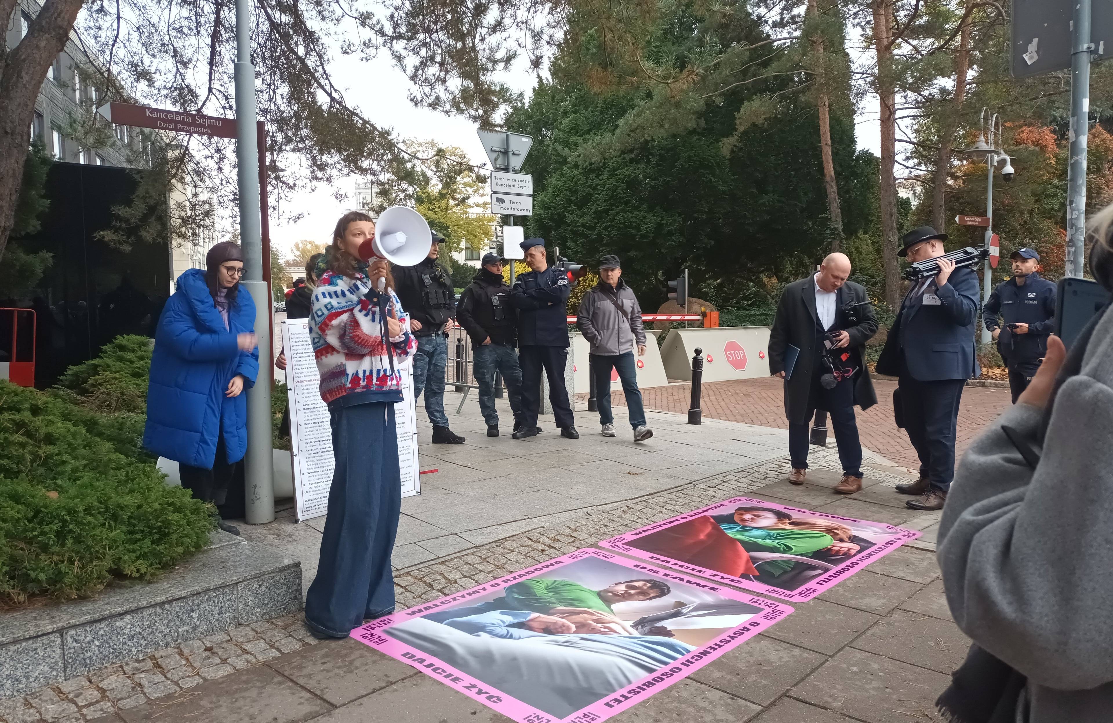 Młoda kobieta z megafonem, na chodniku - zdjęcie osoby z niepełnosprawnościami z matką