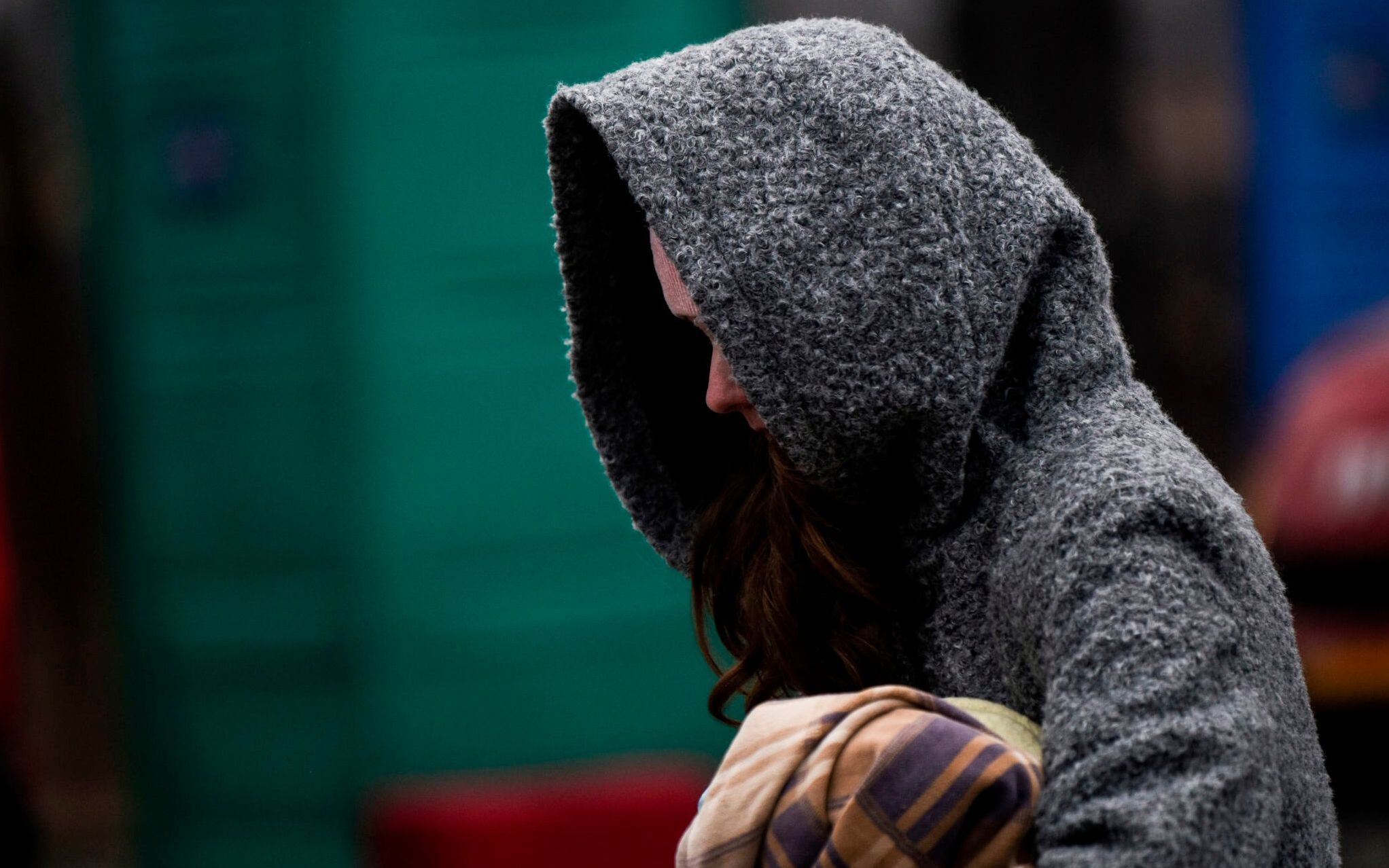 A Ukrainian evacuee wrapped in a blanket walks at the Ukrainian-Romanian border in Siret, northern Romania, on March 16, 2022. - More than three million people have fled Ukraine since the start of the invasion, the UN migration agency IOM says. Around half are minors, says the UN children's agency. (Photo by Armend NIMANI / AFP)