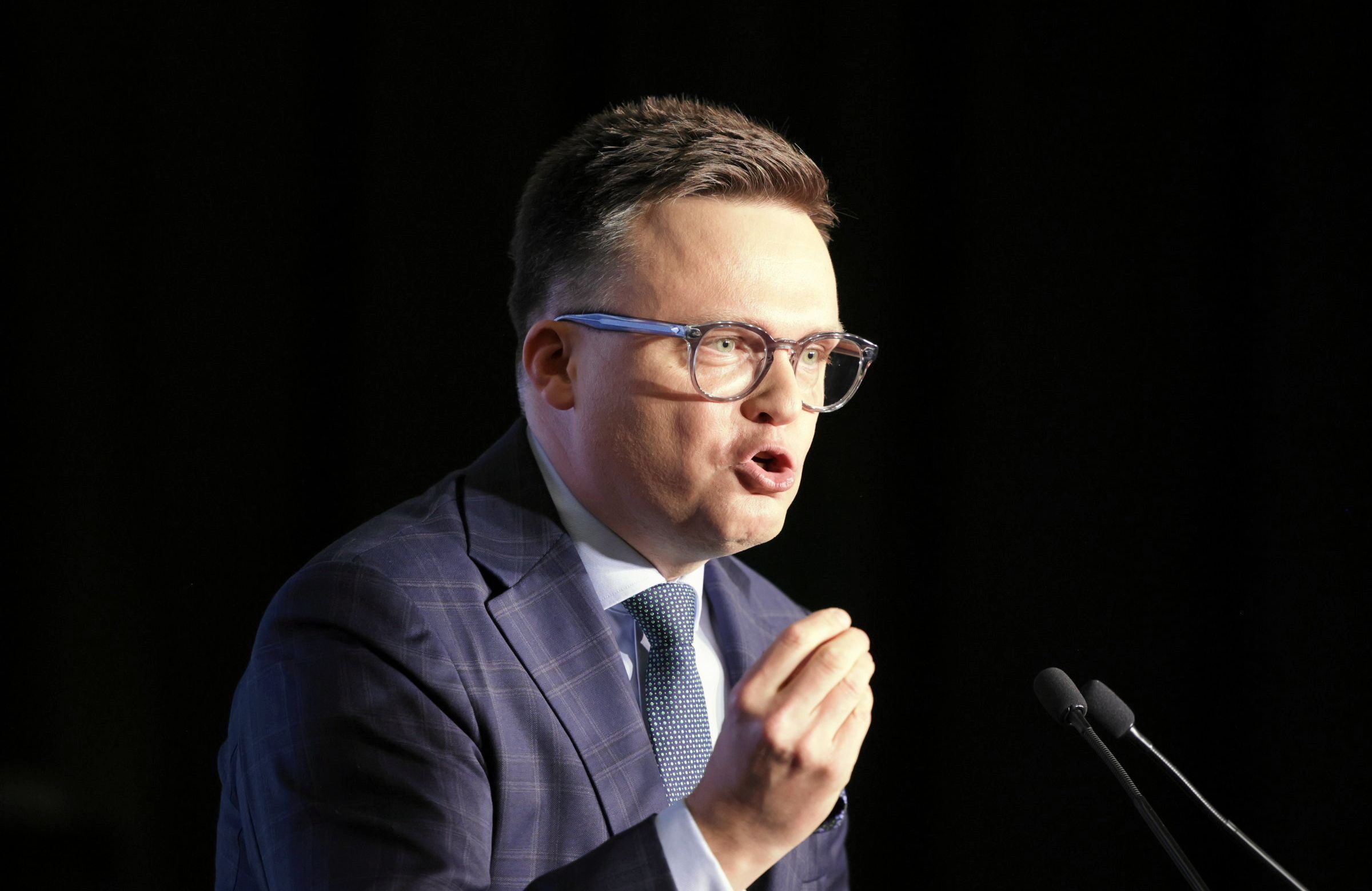 Szymon Hołownia tłumaczy coś przed mikrofonem
