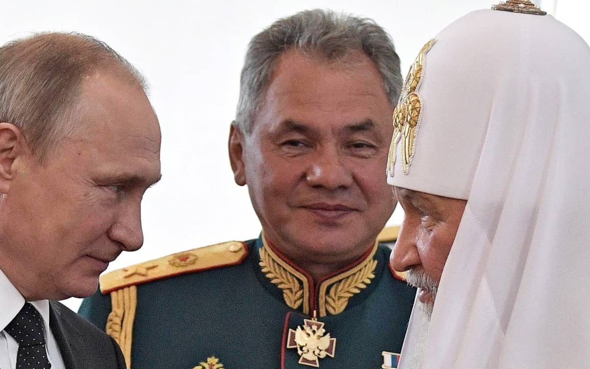 Russian President Vladimir Putin (L), Russian Patriarch Kirill of Moscow (R) and Defence Minister Sergei Shoigu talk while visiting a marine church during Navy Day in Saint Petersburg on July 30, 2017. - President Vladimir Putin oversaw a pomp-filled display of Russia's naval might as the Kremlin paraded its sea power from the Baltic Sea to the shores of Syria. Some 50 warships and submarines were on show along the Neva River and in the Gulf of Finland off the country's second city of Saint Petersburg after Putin ordered the navy to hold its first ever parade on such a grand scale. (Photo by Alexey NIKOLSKY / SPUTNIK / AFP)