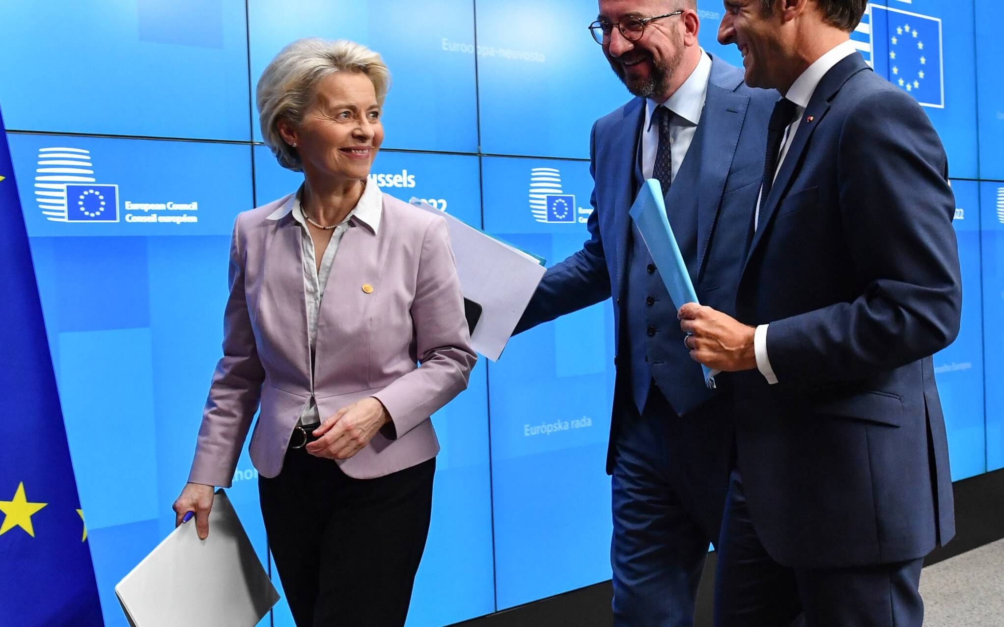 President of the European Commission Ursula von der Leyen (L), President of the European Council Charles Michel (C) and France's President Emmanuel Macron (R) leave after holding a press conference during an European Council in Brussels on June 23, 2022. - European Union leaders on June 23, 2022 agreed to grant "candidate status" to Ukraine and Moldova, in a show of support in the face of Russia's war, EU chief Charles Michel said. (Photo by JOHN THYS / AFP)