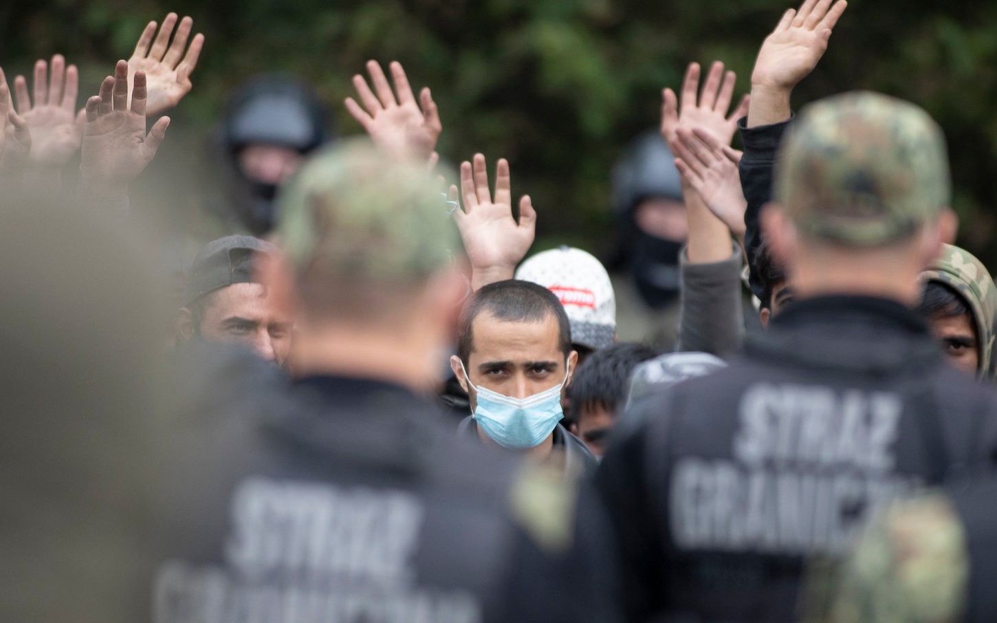 19.08.2021 Usnarz Gorny . Granica polsko - bialoruska . Grupa uchodzcow z Iraku i Afganistanu , w tym kobiety i dzieci , od kilku dni koczujacych na pasie granicznym , tak zwanej '' ziemii niczyjej ''. Pilnuja ich z obu stron granicy uzbrojeni straznicy , nie wpuszczajac do Polski , ani z powrotem na Bialorus .
Fot. Grzegorz Dabrowski / Agencja Gazeta