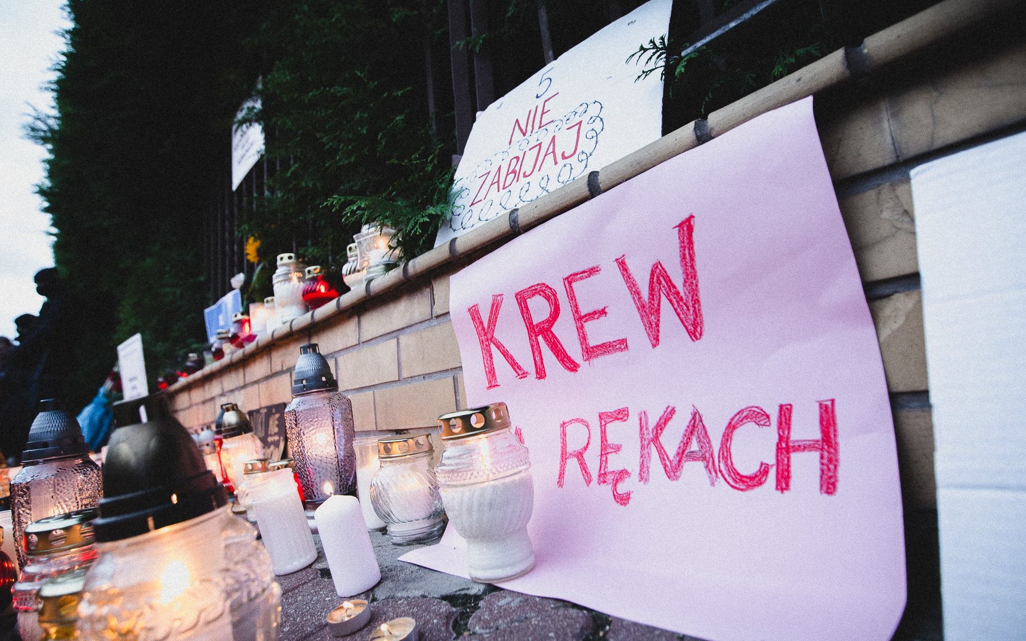 Warszawa, 20.09.2021. 200 osób zapaliło pod Komendą Główną Straży Granicznej znicze dla zmarłych na granicy