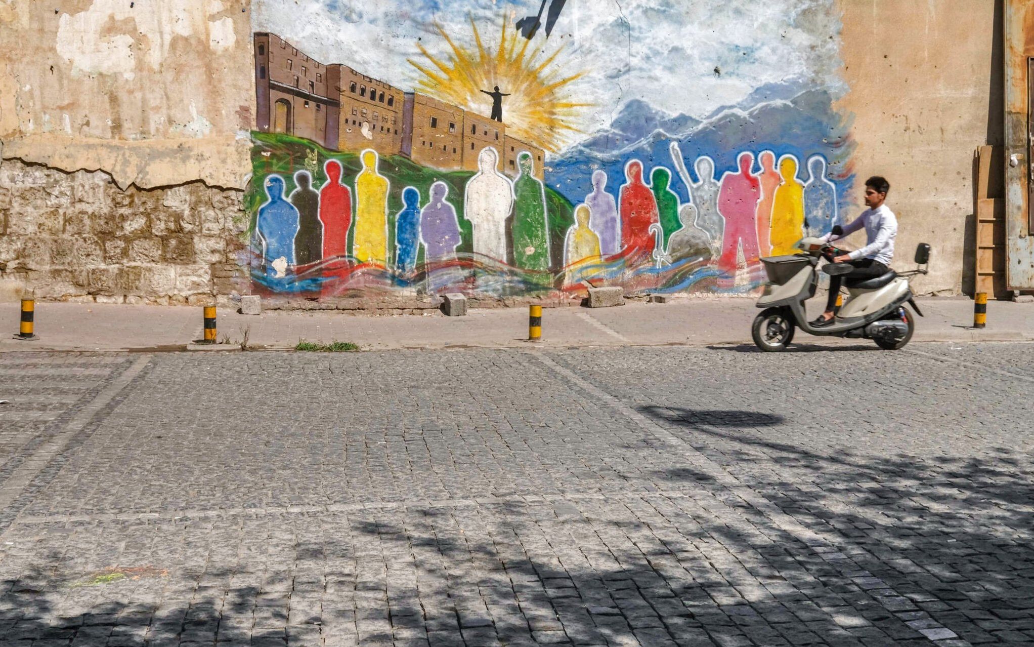 A man rides a scooter outside the Citadel of Arbil in the capital of Iraq's northern autonomous Kurdish region, on July 7, 2021. (Photo by SAFIN HAMED / AFP)