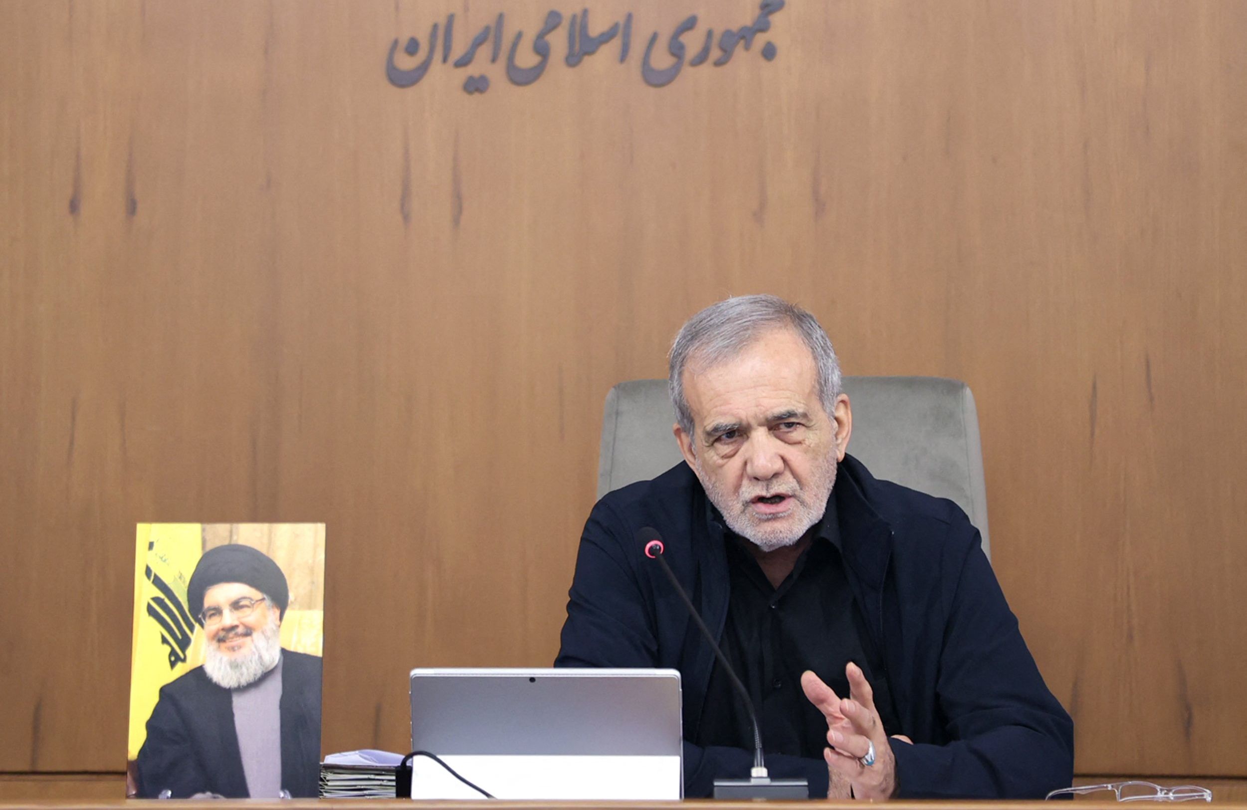 Prezydent Iranu Masud Pezeszkian obok portretu Hassana Nasrallaha