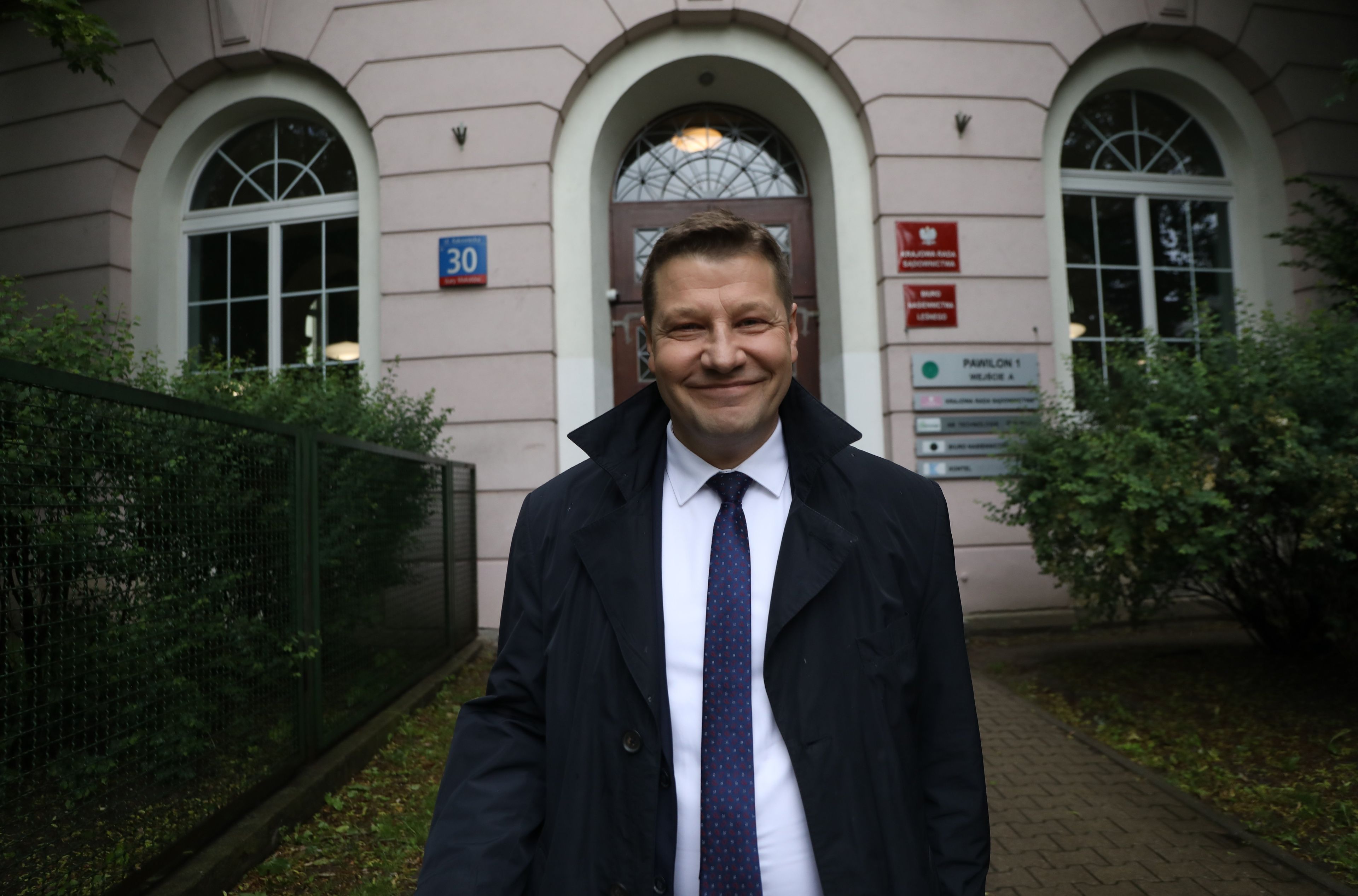 Mężczyzna w graniturze na tlke wysokiego wejścia do Budynku