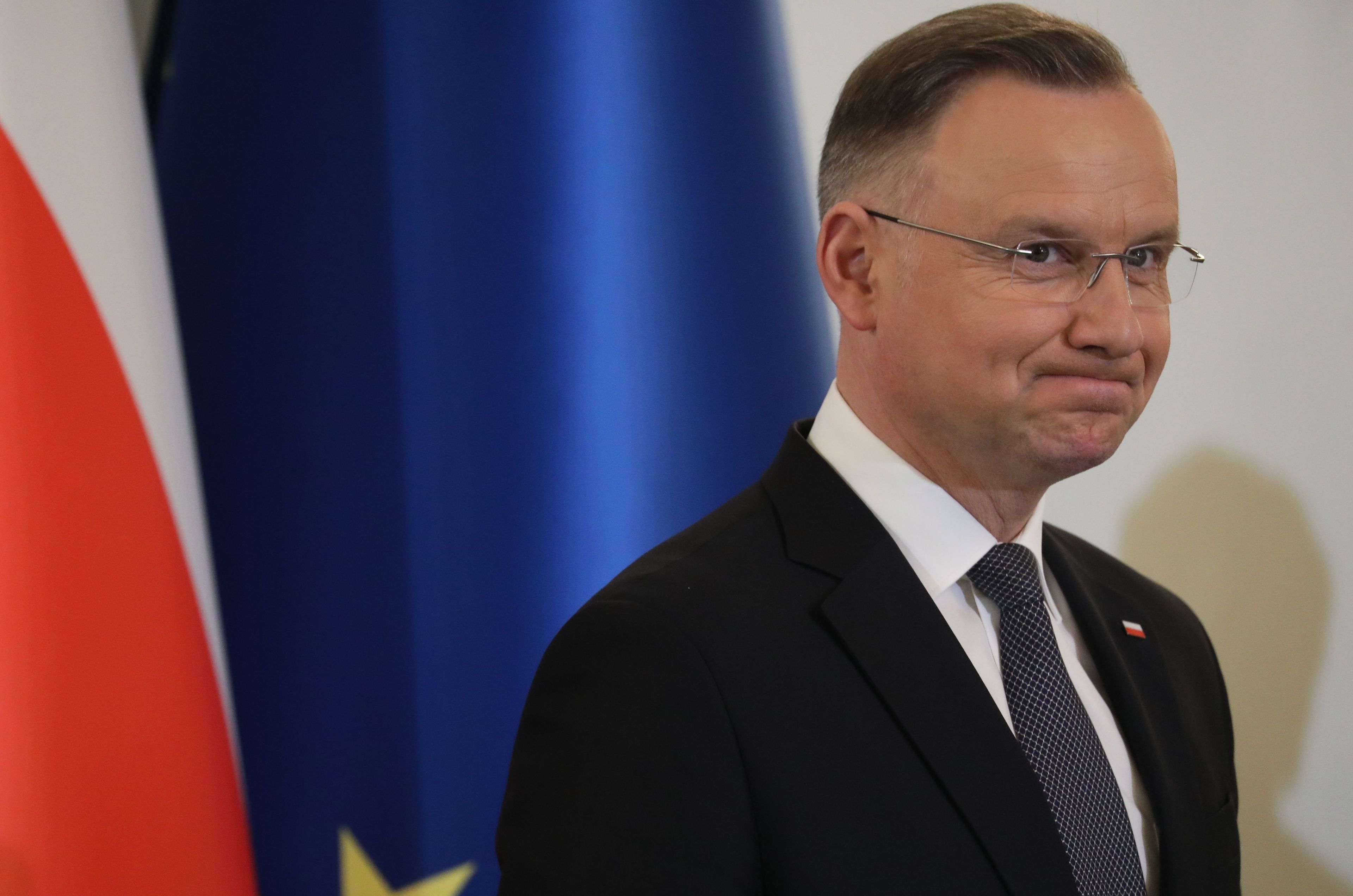 Prezydent Andrzej Duda na tle flag Polski i Unii Europejskiej
