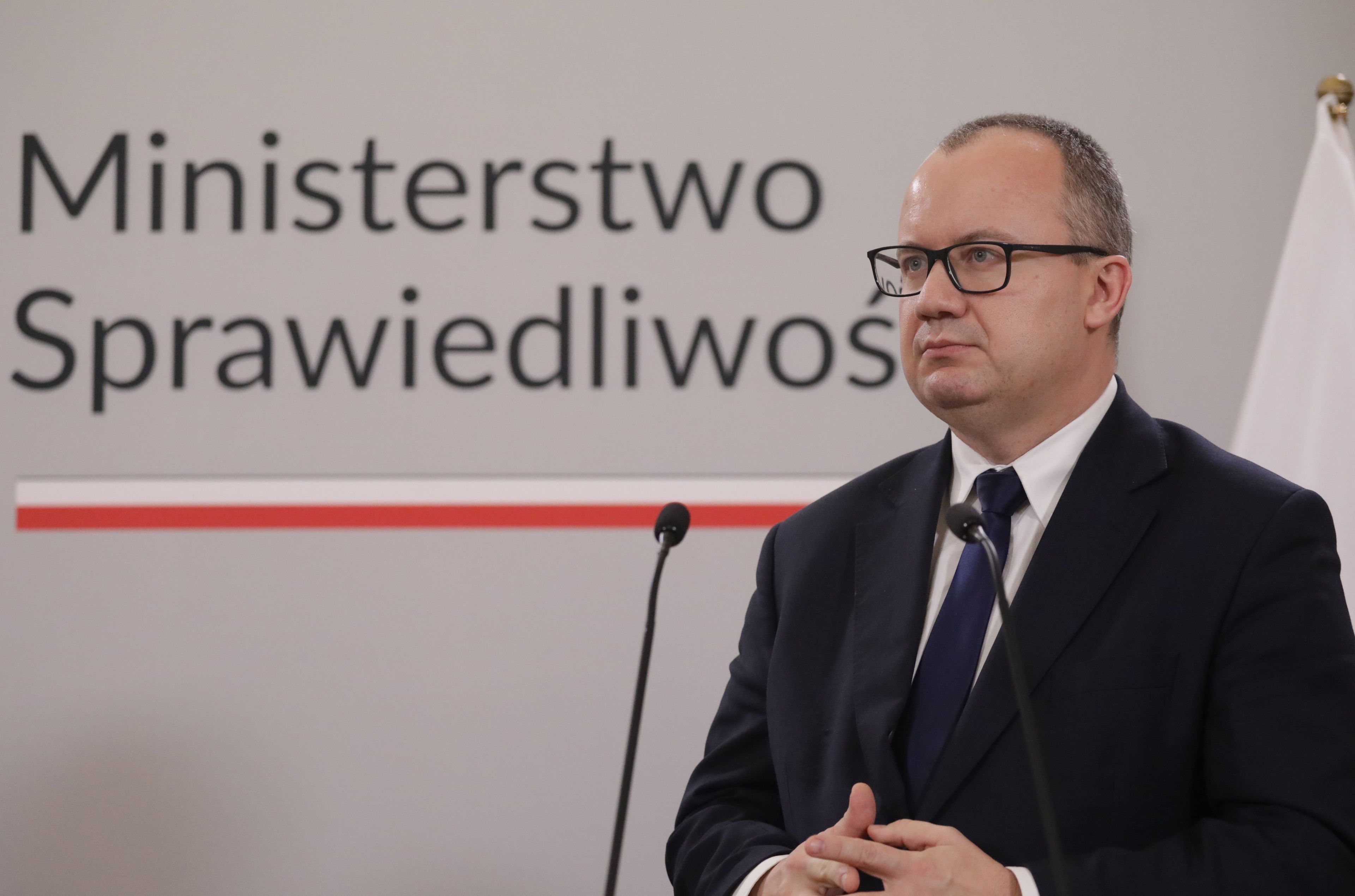 Mężczyzna na tle napisu Ministerstwo Sprawiedliwości