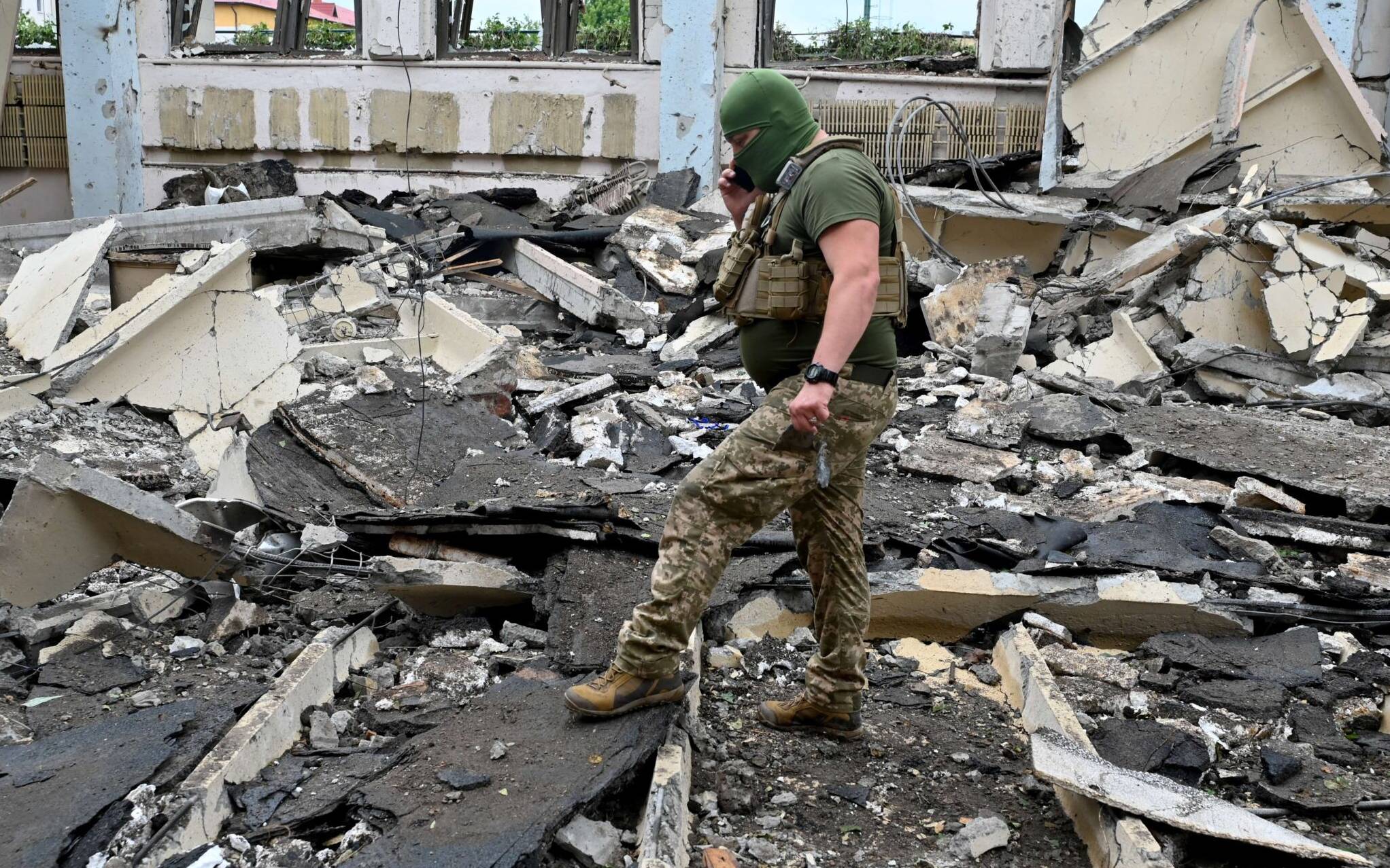 A Ukrainian serviceman walks through the rubbles of a  building of the Polytechnic Sports Complex of the Kharkiv National Technical University after it was hit by Russian missile in Kharkiv on June 24, 2022, amid Russian invasion of Ukraine. (Photo by SERGEY BOBOK / AFP)