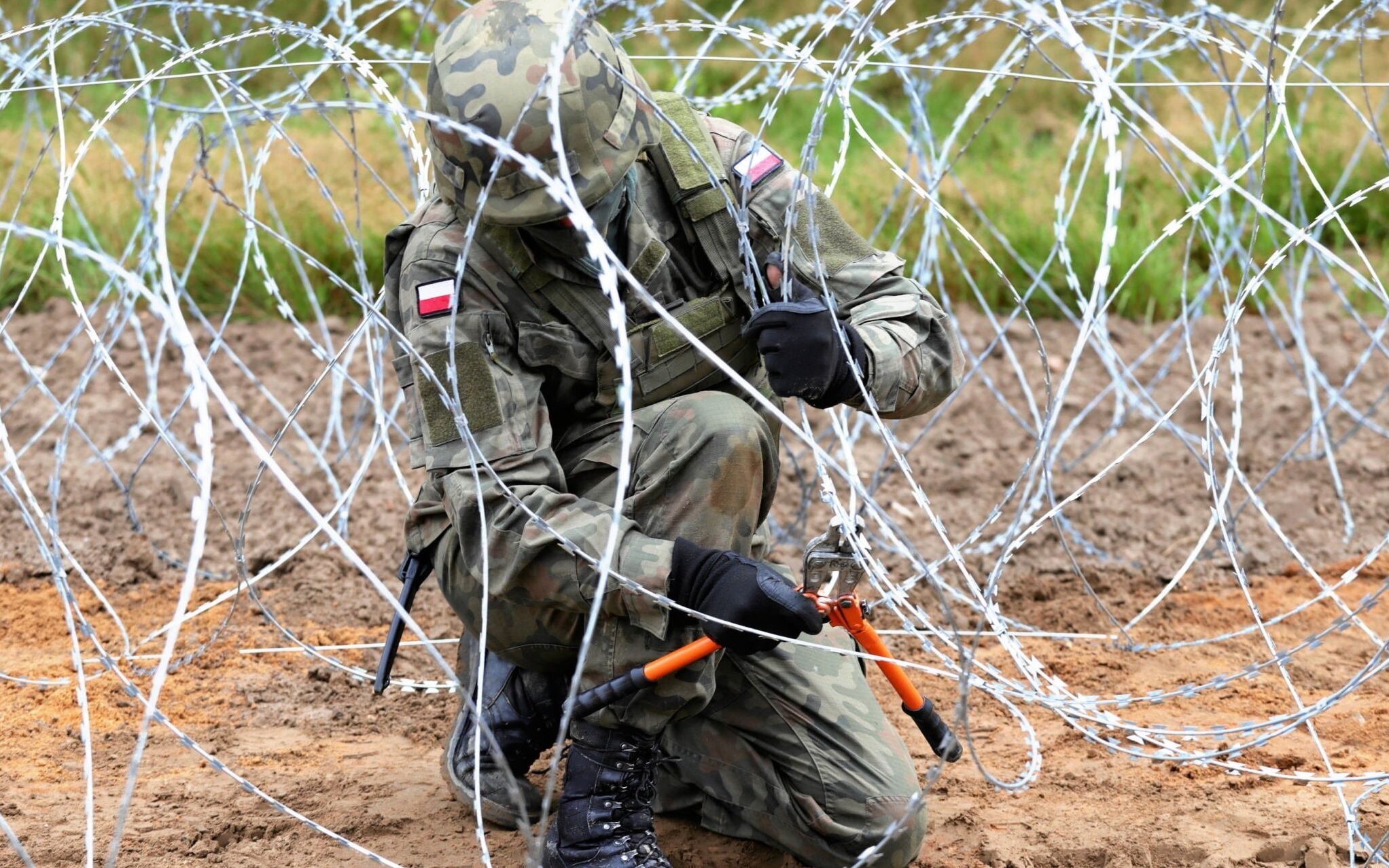 27.08.2021 Granica polsko - bialoruska , miedzy Krynkami i Jurowlanami , wojewodztwo podlaskie . Wojsko podczas budowy plot z drutu kolczastego , o planowanej dlugosci okolo 180 - 190 kilometrow na granicy polsko - bialoruskiej majacej 418 kilometrow , w zwiazku z nielegalnym przekraczaniem granicy . W pierwszej kolejnosci powstanie na 150 - kilometrowym odcinku granicy z Bialorusia , gdzie straz graniczna odnotowuje najwiecej prob nielegalnego przekroczenia granicy .
Fot. Grzegorz Dabrowski / Agencja Gazeta