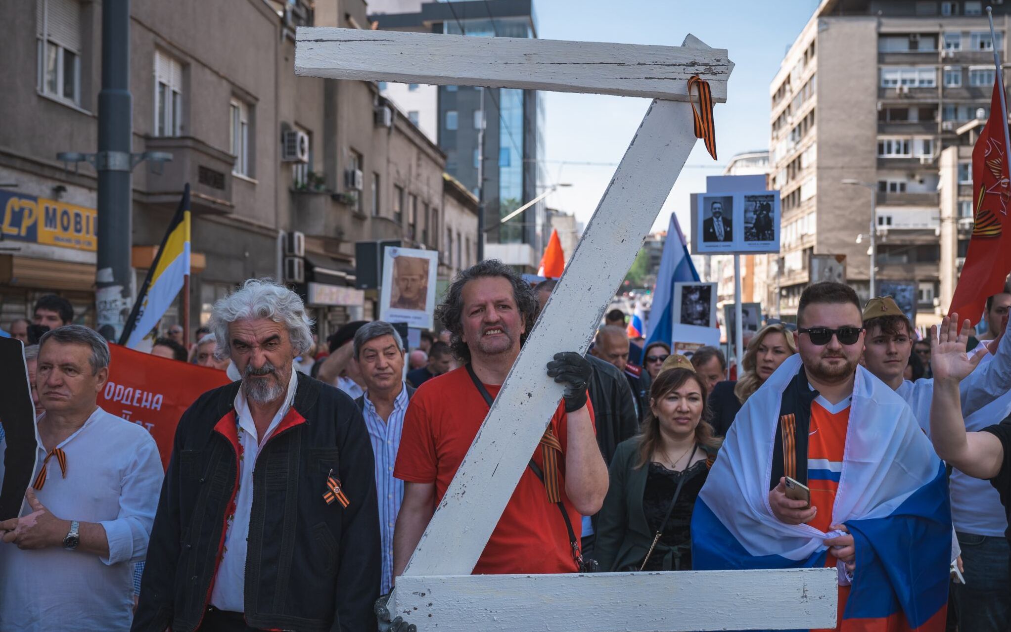 A man carries a giant letter "Z", which has become a symbol of support for Russian military action in Ukraine, during the "Immortal Regiment" march in Belgrade on May 9, 2022. - About 200 people took part in the march of the "Immortal Regiment" organized in Belgrade by the Russian Embassy to mark the Soviet victory over the Nazis in 1945. The participants marched in silence holding the portraits of the young people dead in the battlefields. (Photo by Andrej ISAKOVIC / AFP)