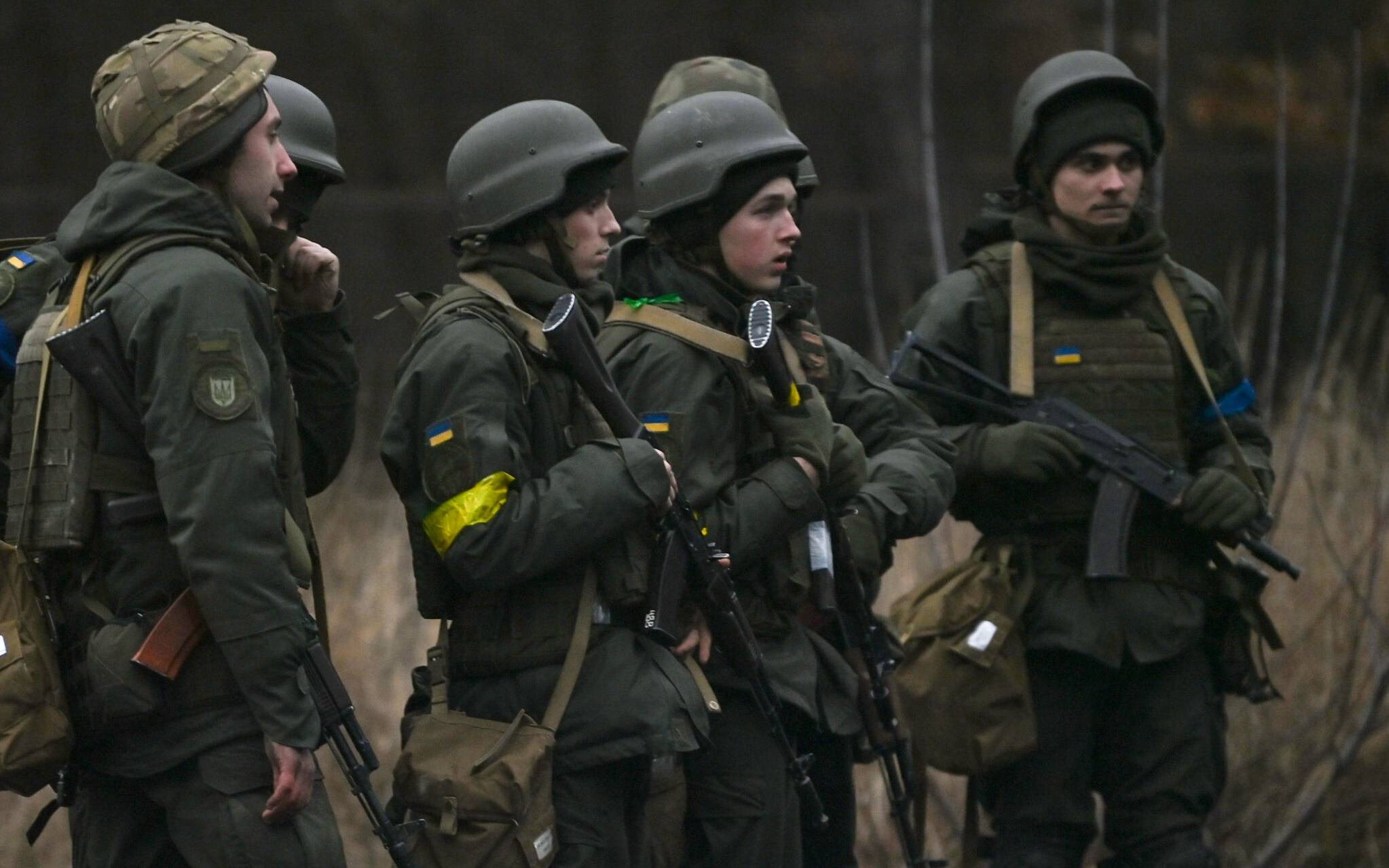 Ukrainian servicemen stand on the north of Kyiv on February 24, 2022. - Russian and Ukrainian forces are battling for control of an airbase on the northern outskirts of Kyiv, a senior Ukrainian officer said on February 24, 2022, as dozens of attack helicopters swooped on the area. (Photo by Daniel LEAL / AFP)