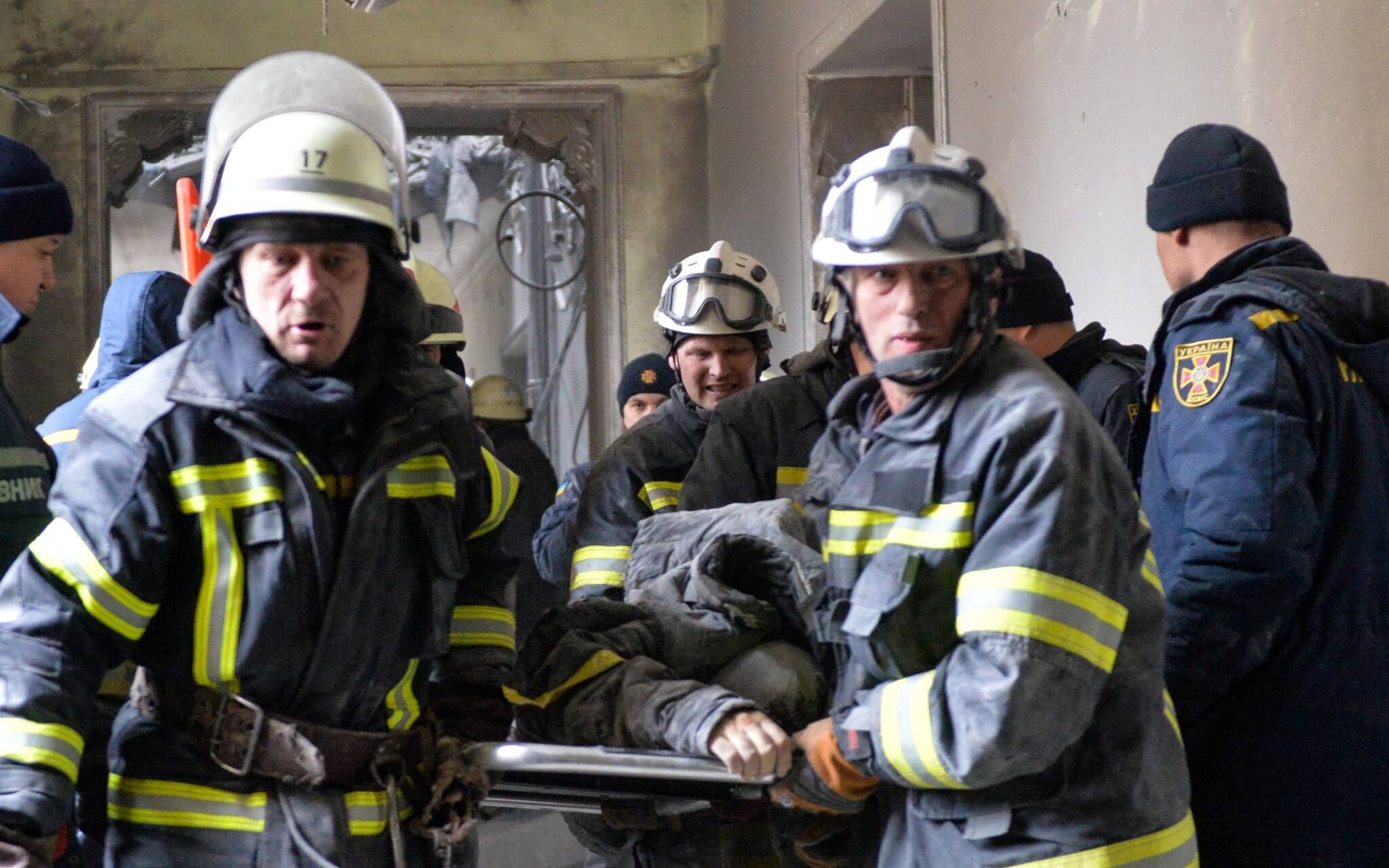 Emergencies personnel carry the body out of the damaged local city hall of Kharkiv on March 1, 2022, destroyed as a result of Russian troop shelling. - The central square of Ukraine's second city, Kharkiv, was shelled by advancing Russian forces who hit the building of the local administration, regional governor Oleg Sinegubov said. Kharkiv, a largely Russian-speaking city near the Russian border, has a population of around 1.4 million. (Photo by Sergey BOBOK / AFP)