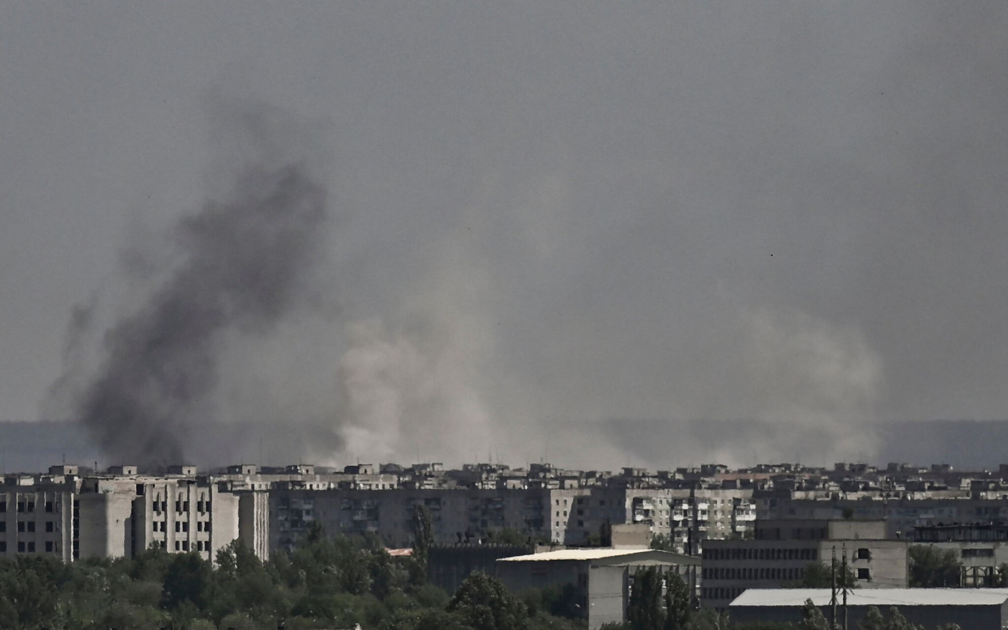 Smoke and dirt rise from the city of Severodonetsk, during shelling in the eastern Ukrainian region of Donbas, on May 26, 2022, amid Russia's military invasion launched on Ukraine. - Ukraine said may 26 the war in the east of the country had hit its fiercest level yet as it urged Western allies to match words with support against invading Russian forces. Moscow's troops are pushing into the industrial Donbas region after failing to take the capital Kyiv, closing in on several urban centres including the strategically located Severodonetsk and Lysychansk. (Photo by ARIS MESSINIS / AFP)