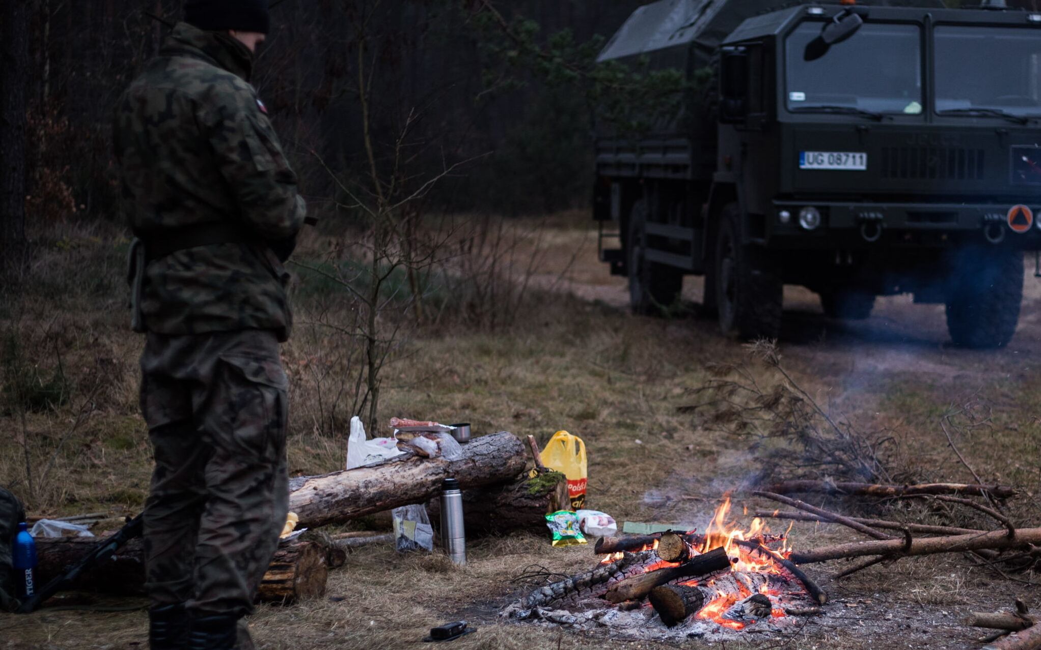 18.11.2021 Nurzec . Miejsce stacjonowania wojska przy strefie stanu wyjatkowego wytyczonej w rejonie granicy z Bialorusia w zwiazku z naplywem migrantow przez granice polsko - bialoruska . Zolnierz na posterunku przy ognisku w chlodny wieczor . 
Fot. Jakub Wlodek / Agencja Wyborcza.pl
