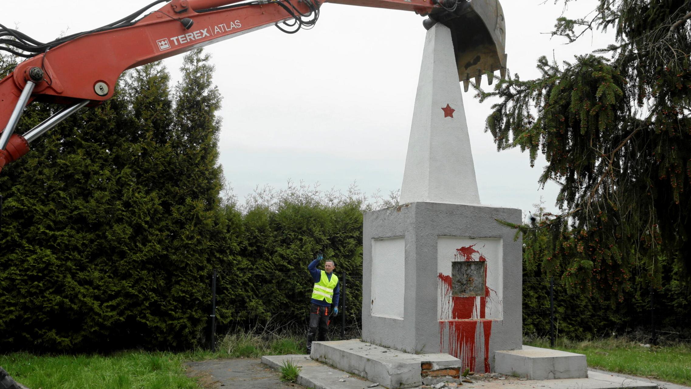 Koparka demontuje pomnik oblany czerwoną farbą