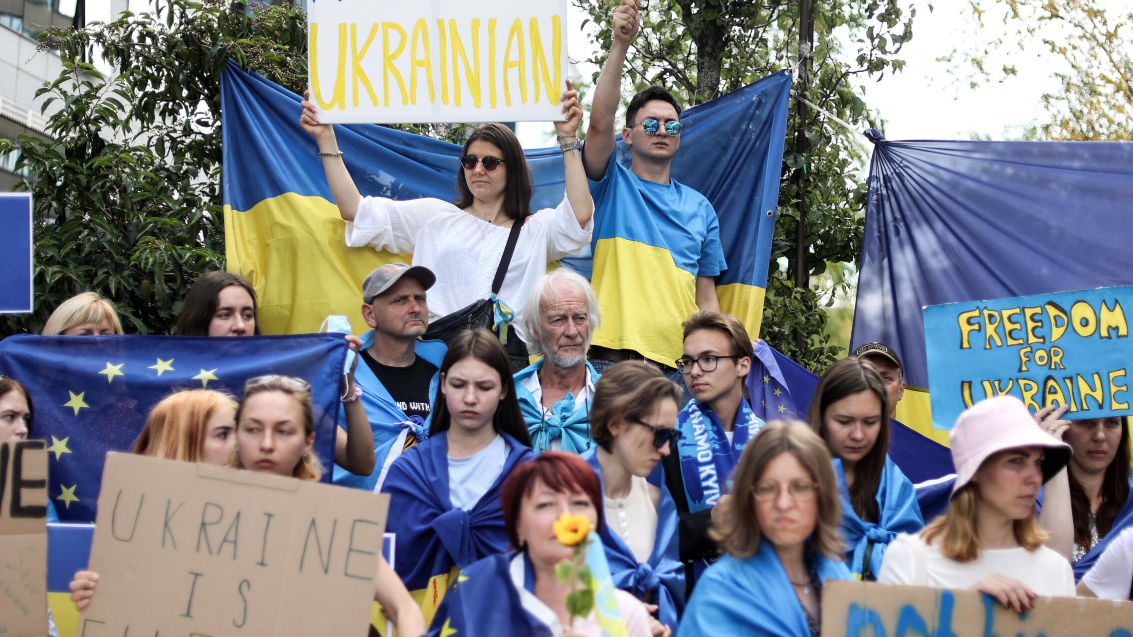 Demonstranci gromadzą się przed główną siedzibą Unii Europejskiej, protestując na rzecz poparcia wniosku Ukrainy o przyznanie jej statusu kandydata do UE podczas spotkania przywódców państw UE i Bałkanów Zachodnich w Brukseli 23 czerwca 2022 r.